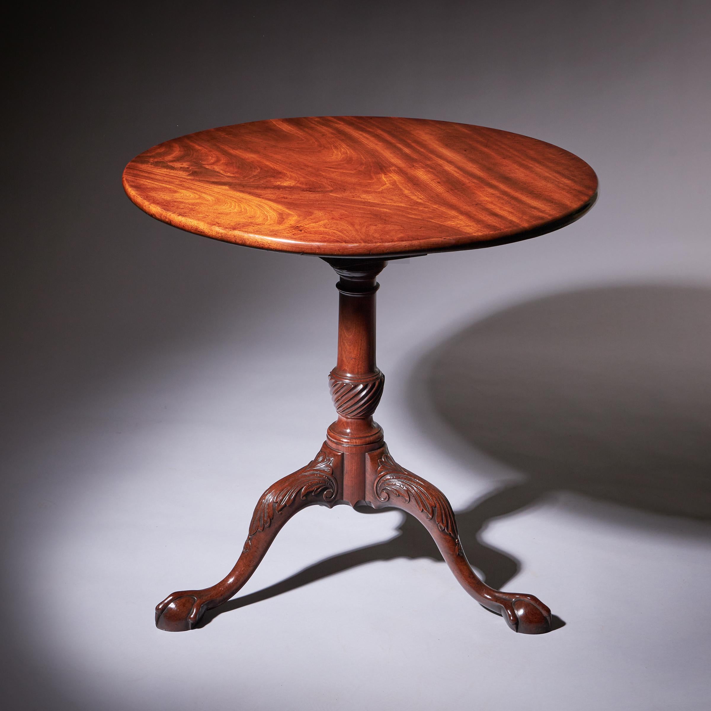 Cette table George II du XVIIIe siècle présente un magnifique plateau circulaire d'une seule pièce d'acajou figuré richement grainé, mettant en valeur l'éclat et les motifs naturels du bois. La table est soutenue par une seule colonne bien tournée