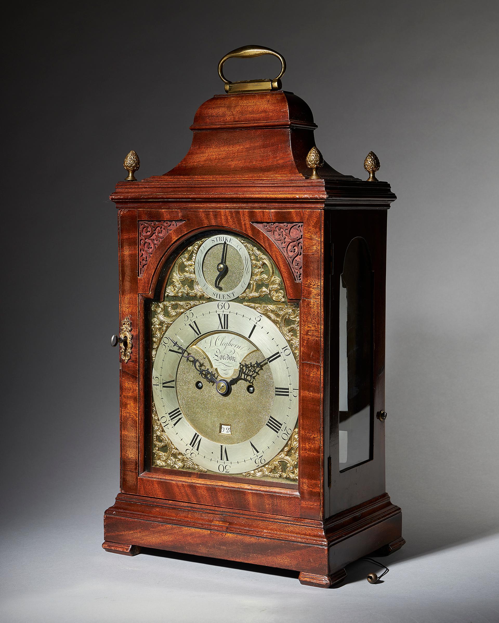 An 18th century English spring-driven mahogany table clock, signed on both the dial and the backplate S. Cleghorn London, made circa 1770-1775. The case is of classical shape for the period, with a bell top, arched doors to the front and rear, and