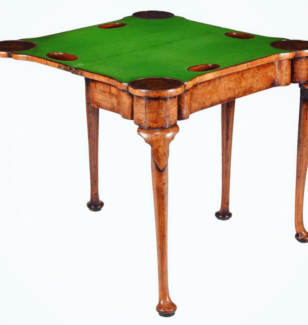 A fine and rare Queen Anne burr and highly figured walnut card table, circa 1710 England. 

The feather and cross banded book-matched top opens on original hinges to reveal a baize lined interior with figured walnut candle stands and counter