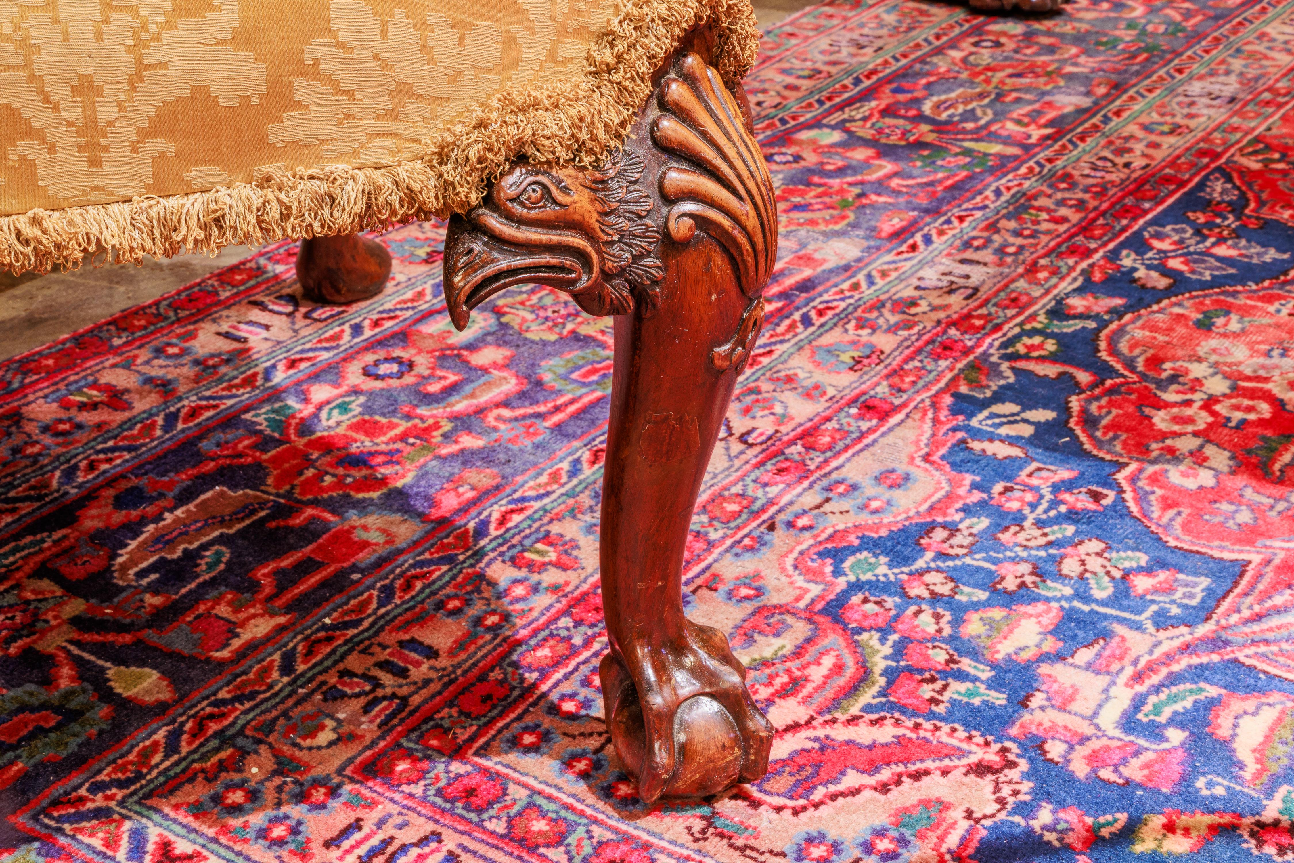 A fine 19th century English carved walnut wingchair. Hand carved with eagles heads and ball and claw feet .