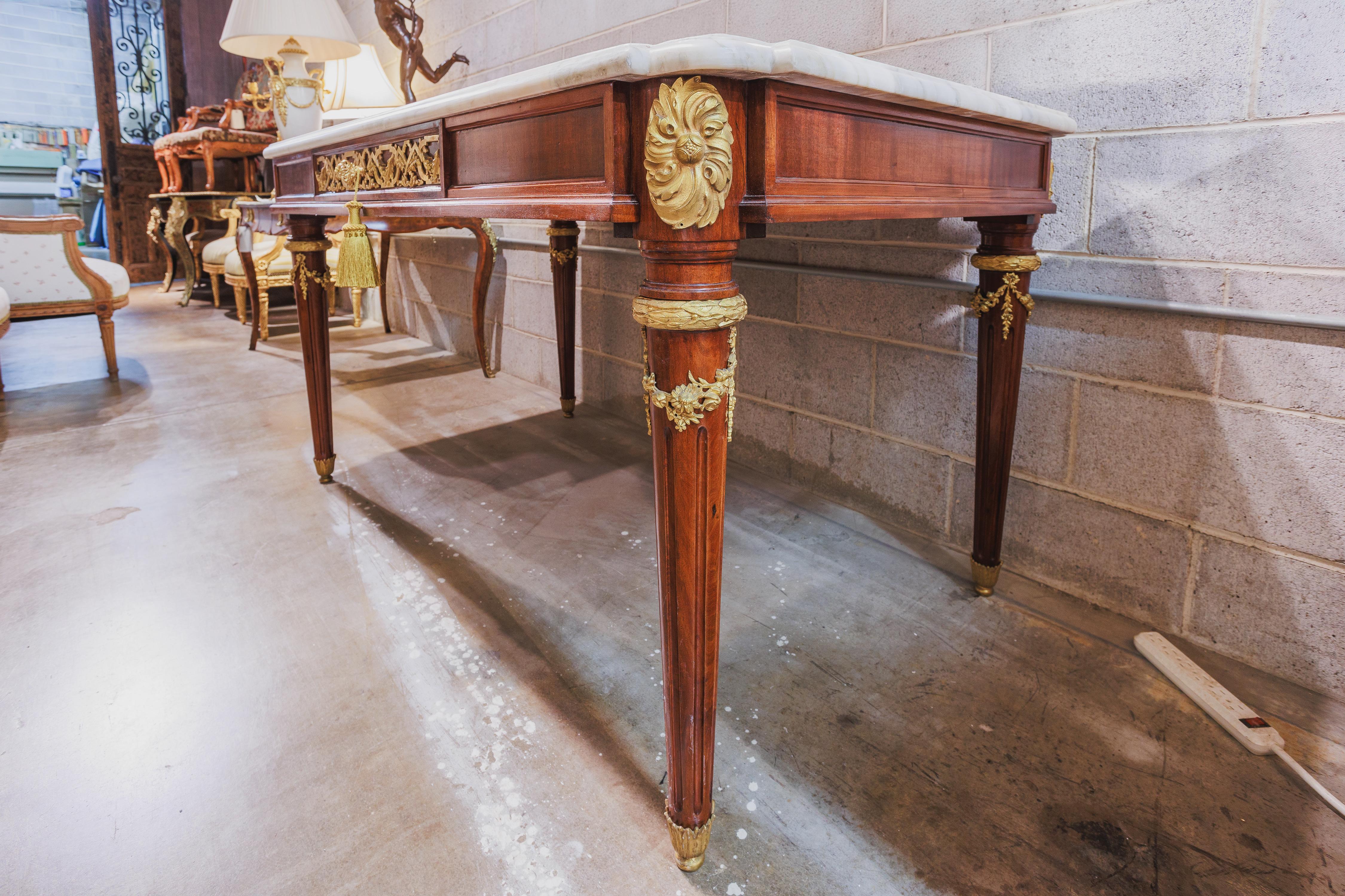 A fine 19th century French Louis XVI mahogany and gilt bronze mounted center hall table. The gilt bronze of fine quality with details on the front and the back . A single drawer so the the table can be used as a desk in the center of a room . The