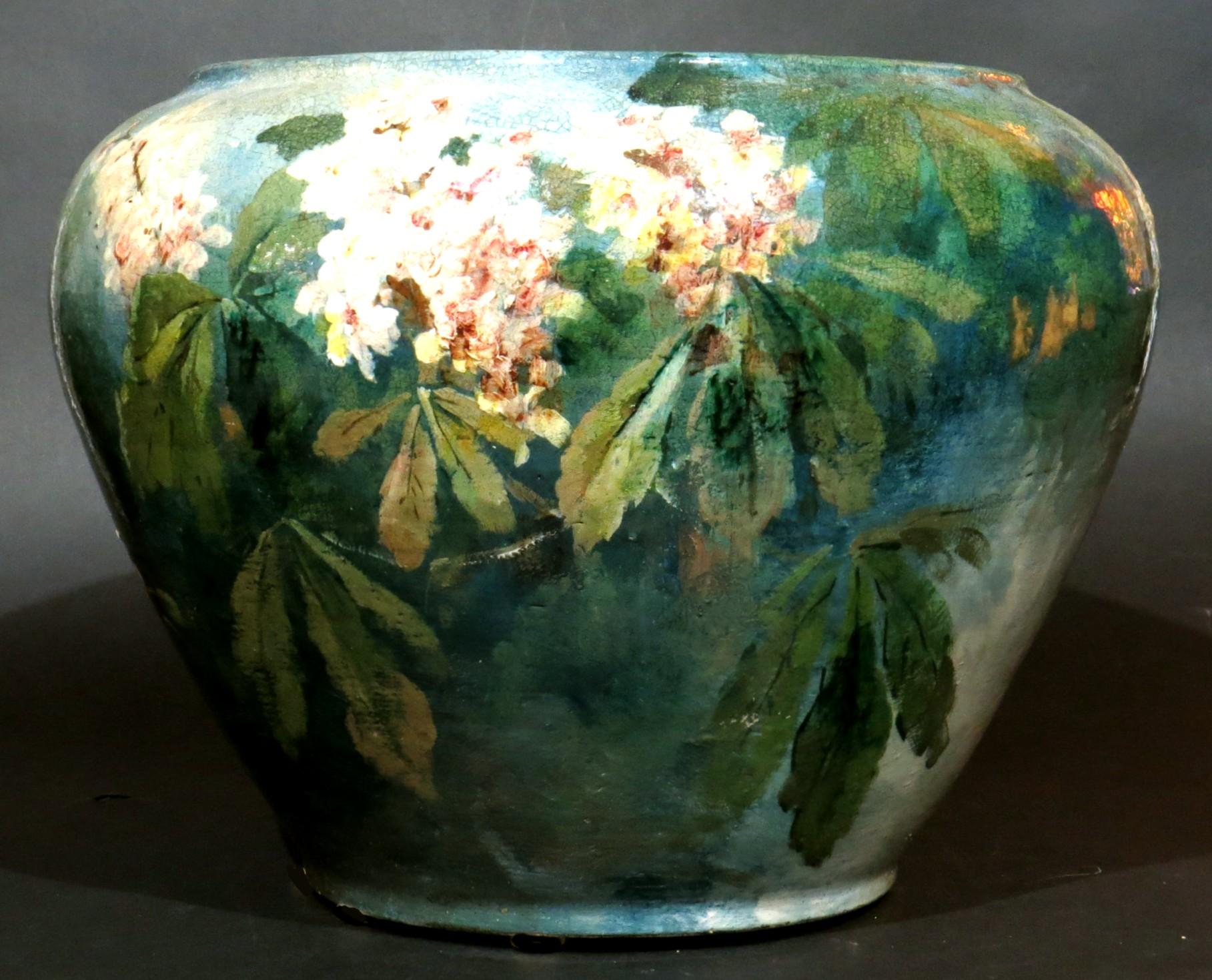 A large & beautifully hand painted Art Nouveau ceramic jardiniere, decorated overall in enamels depicting songbirds perched among blossoming branches & leafy sprays, signed with artists signature in script `Jean'. The underside bearing stamped