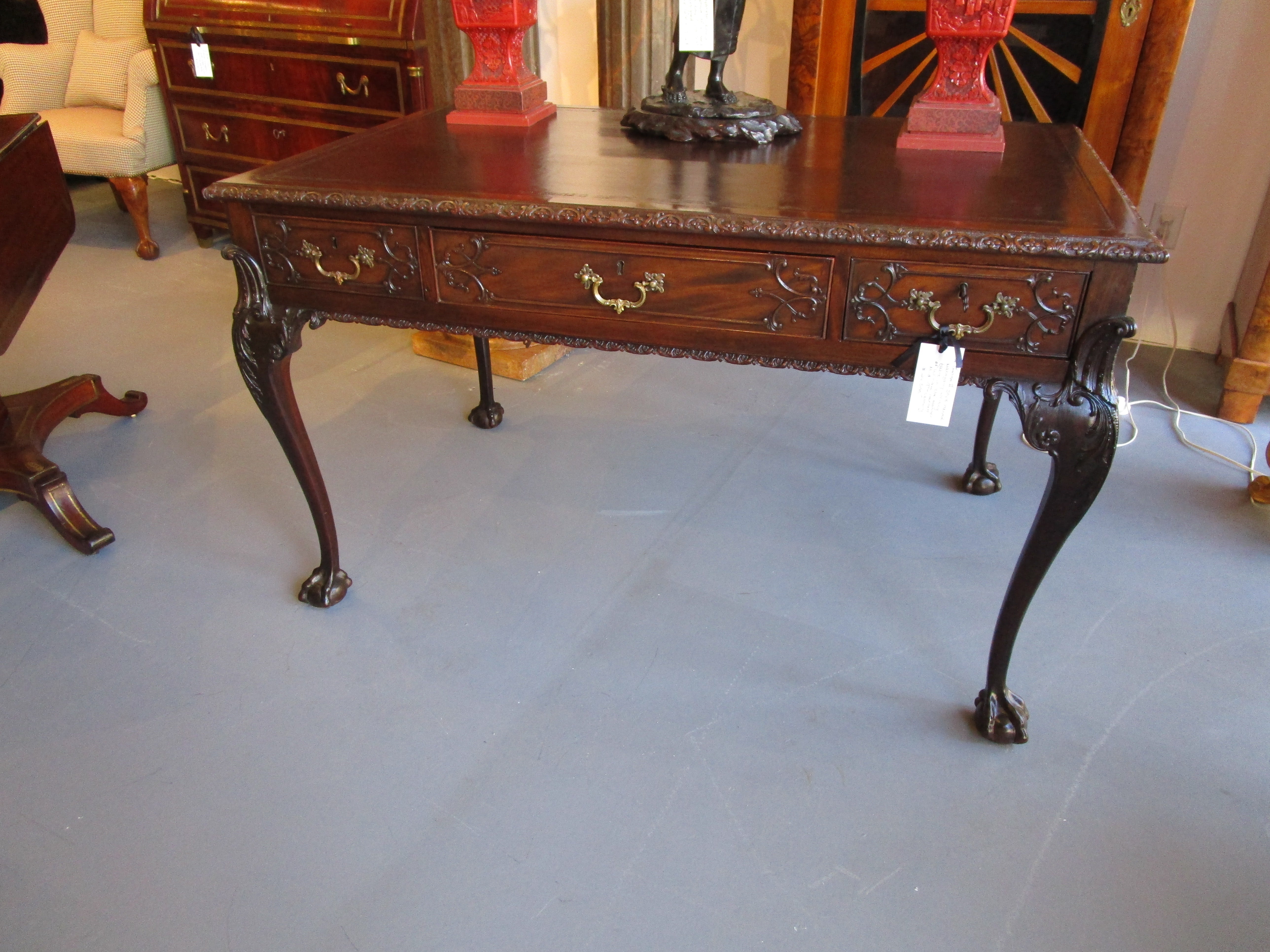 A very fine 19th century George 11 mahogany and leather top writing desk. Hand carved and details on both sides. Beautiful quality with a felt top writing surface. In the manner of William Harllett.