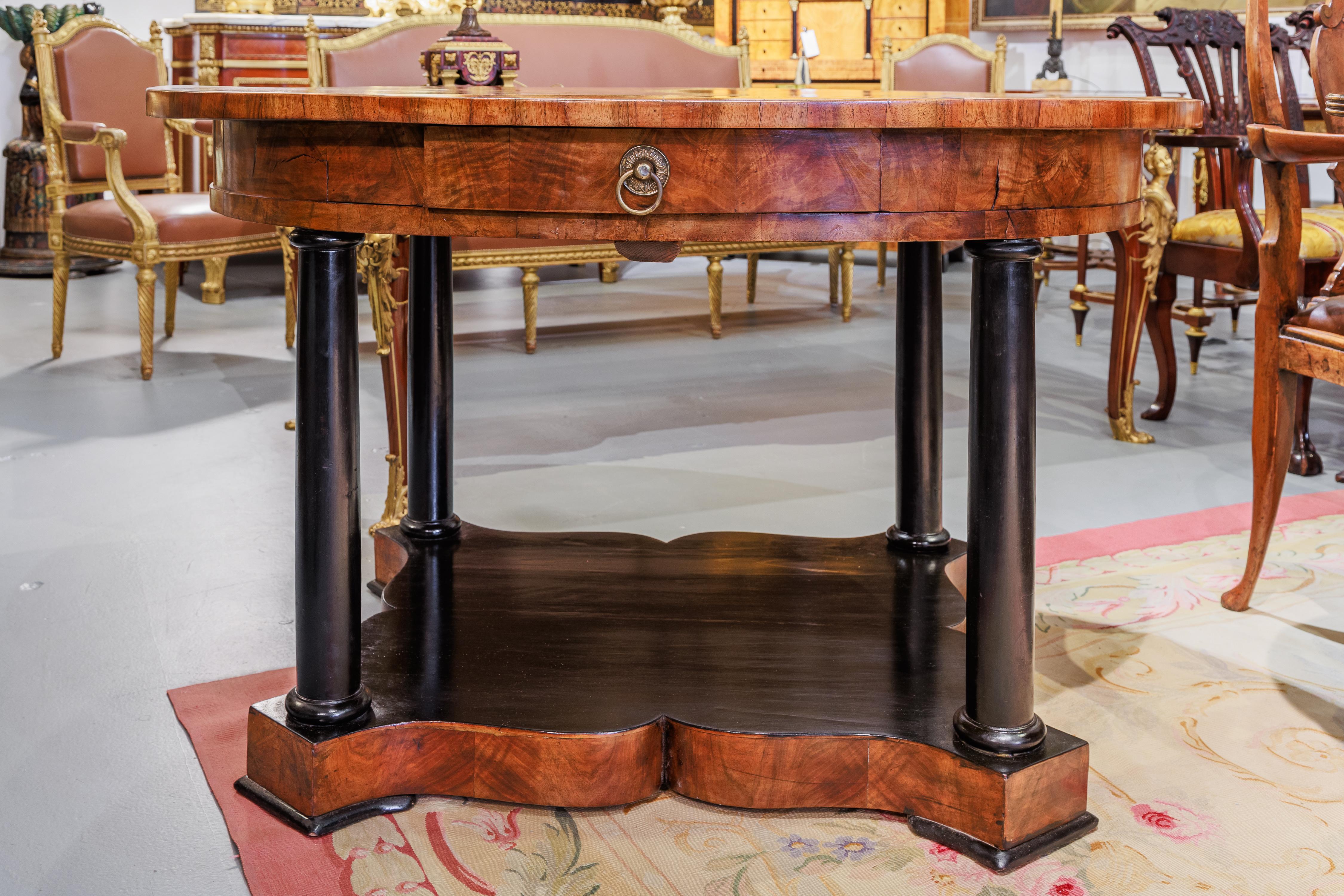 A fine and rare 19th century Austrian Biedermeier walnut and ebonized centertable or breakfast table. Having 4 legs and a platform base in ebonized wood . The top and the single drawer made from walnut veneers. 