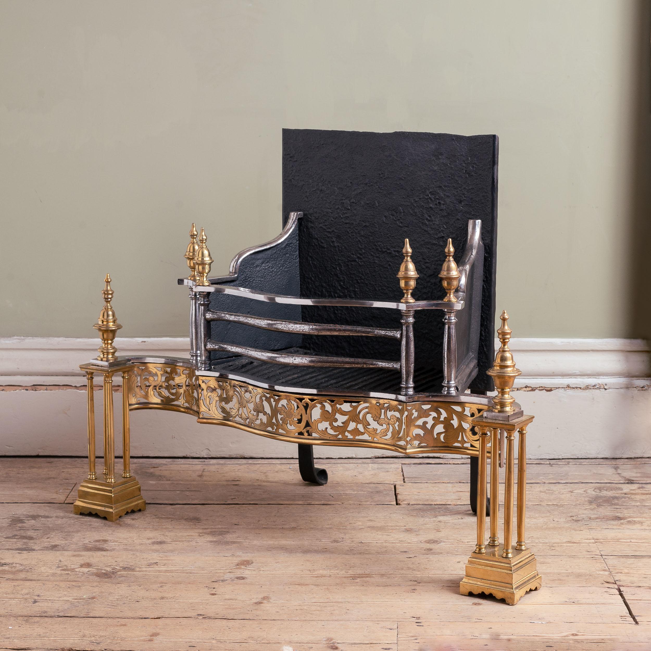 A Fine nineteenth century brass and iron firegrate, mid-Victorian in the Georgian style, by Longden & Co of Sheffield, the serpentine railed basket flanked by double column supports, each with urn finial, the elegant engraved and fret-cut serpentine
