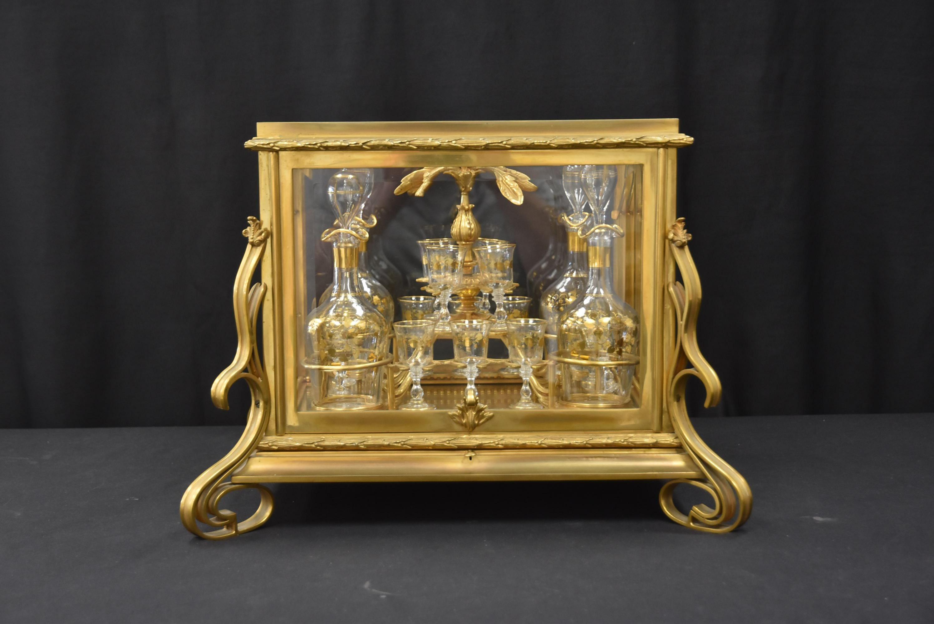 Ensemble de tantale en verre et bronze français du 19ème siècle avec (4) carafes en verre décorées d'or et (14) verres à cordiaux dans un insert en bronze ajusté, dans un coffret en verre et bronze français - Dimensions : 18