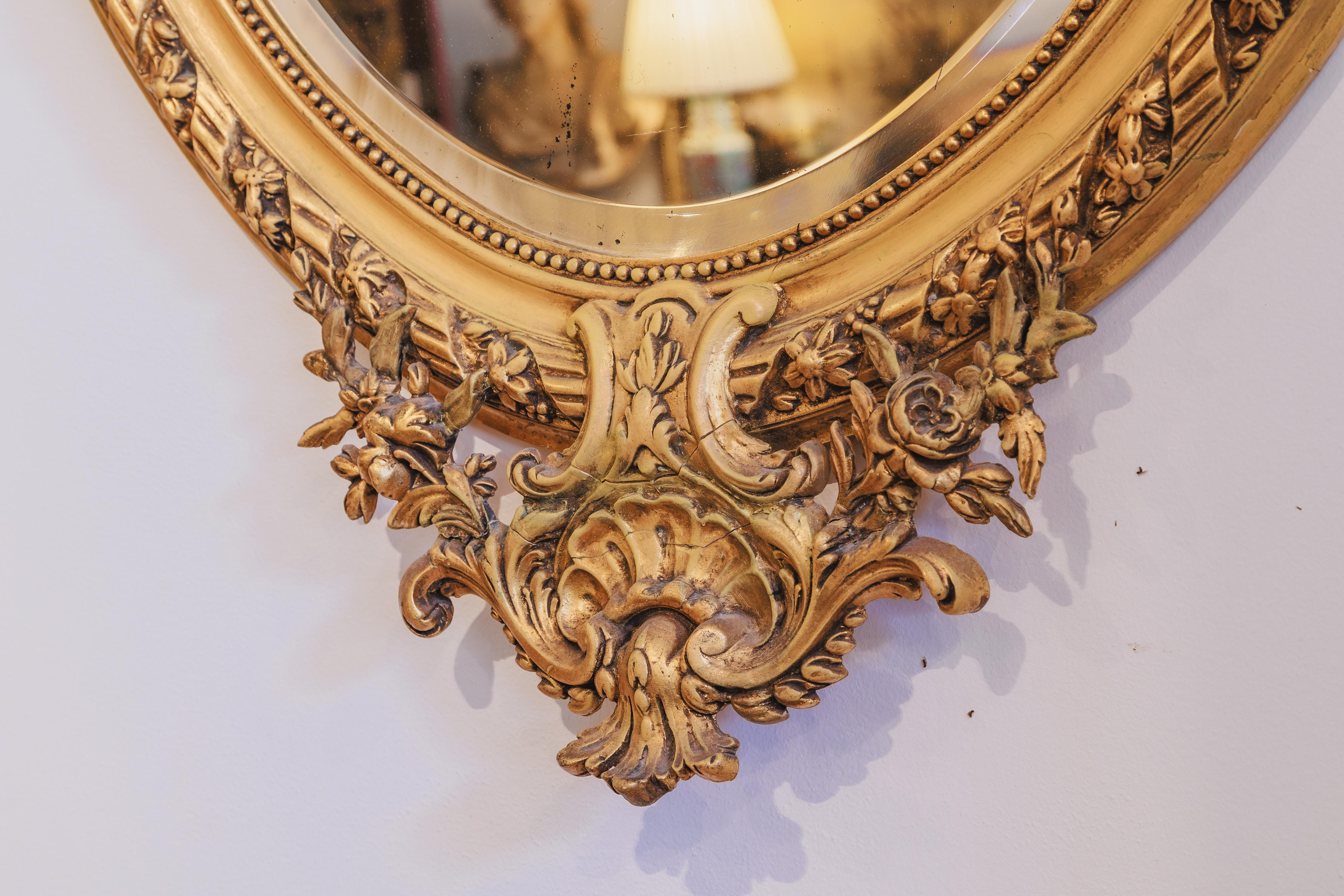 A very fine 19th century French carved and gilt oval mirror .