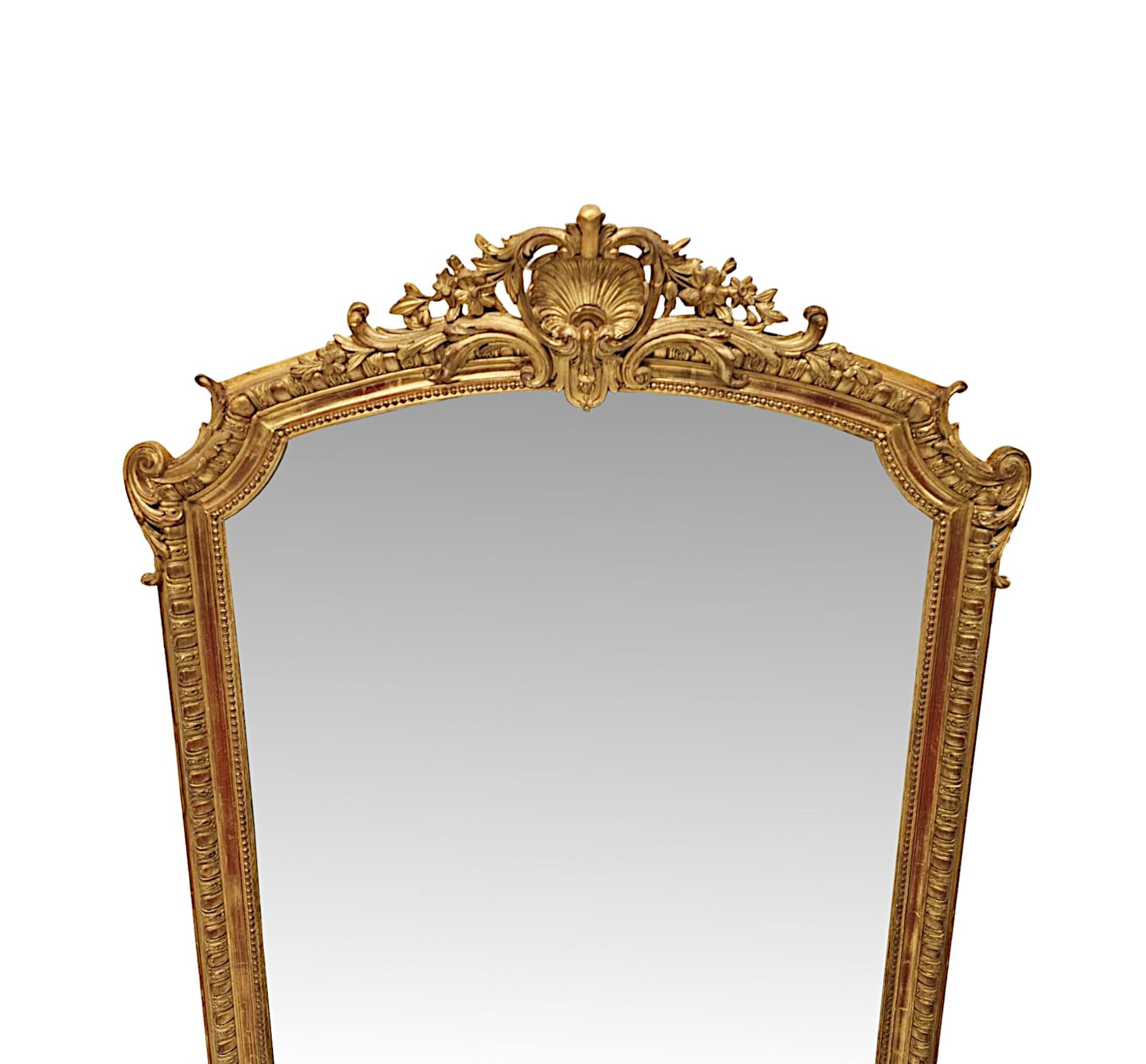 Specchio in legno dorato del XIX secolo di eccezionale qualità, con cartiglio centrale a conchiglia.  La lastra di vetro a specchio sagomata è incastonata in una cornice di legno dorato superbamente intagliata a mano, modellata e scanalata, ornata