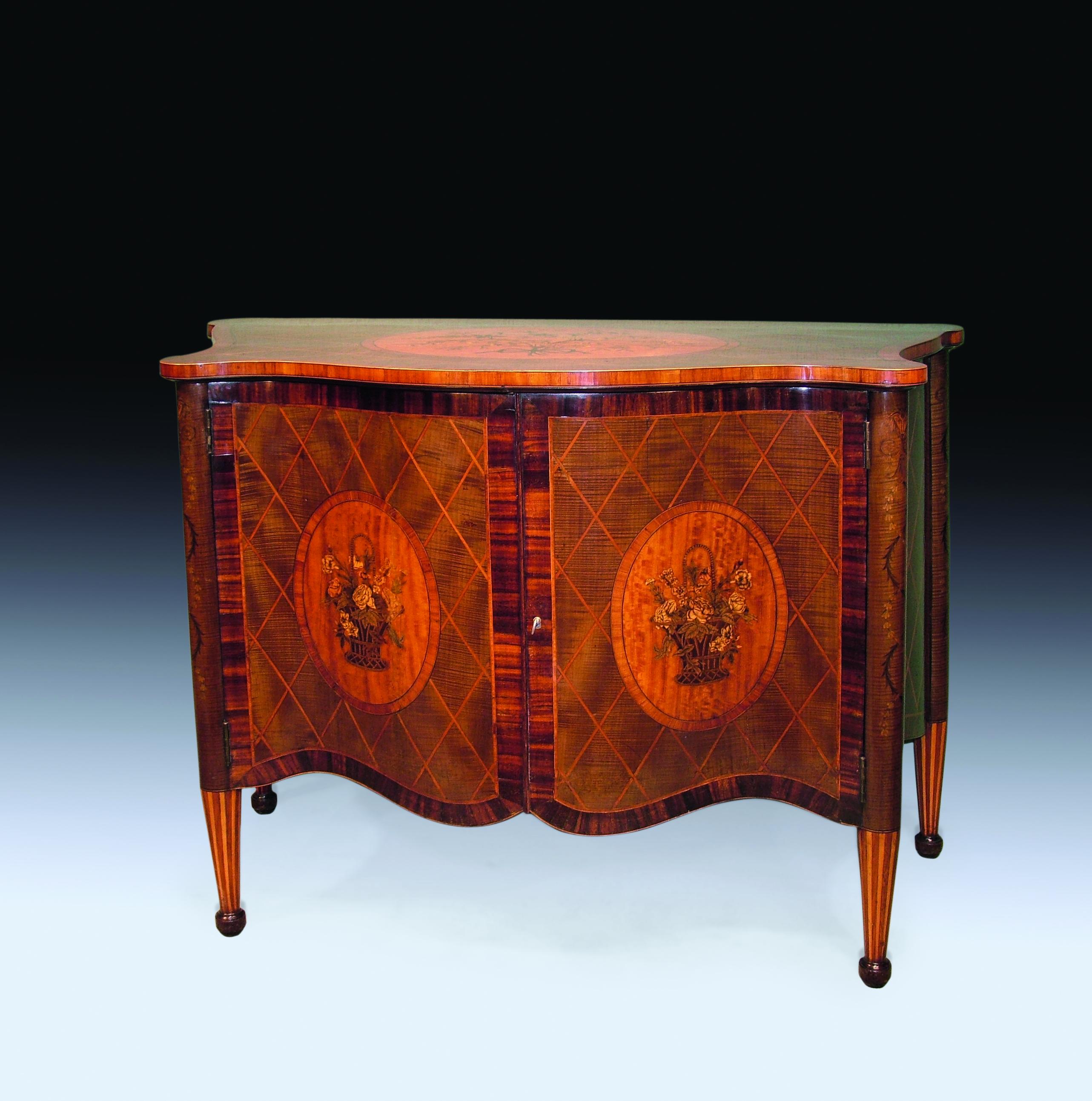 A fine 19th century harewood and diamond lattice-work serpentine commode in the mid-18th century style, having tulipwood crossbanded top with inset oval satinwood floral marquetry inlaid satinwood panel above shaped doors with similar panels inlaid