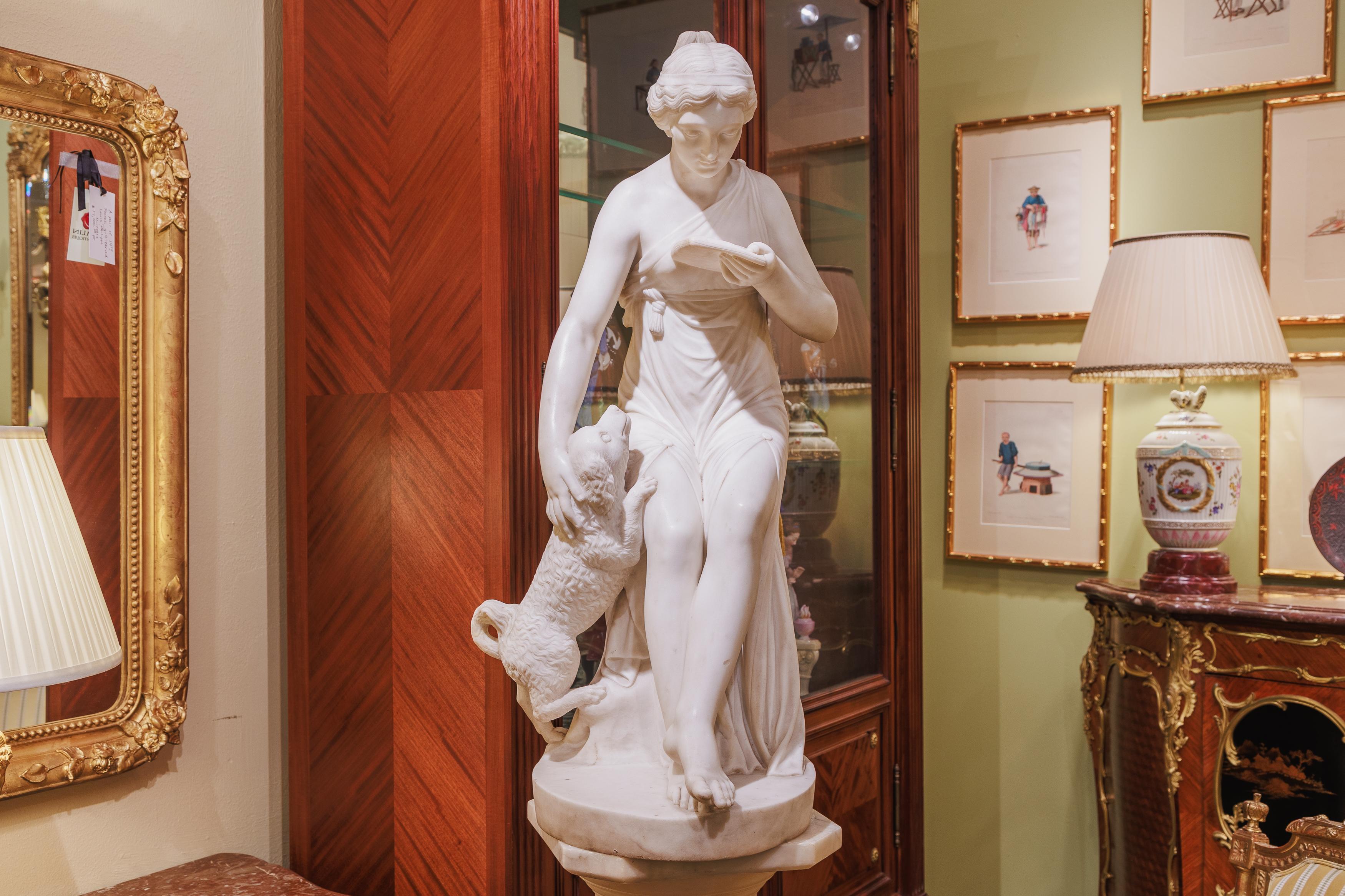A fine 19th century Italian Carrera marble hand carved female seated with her dog. Carrera marble pedestal included and optional.