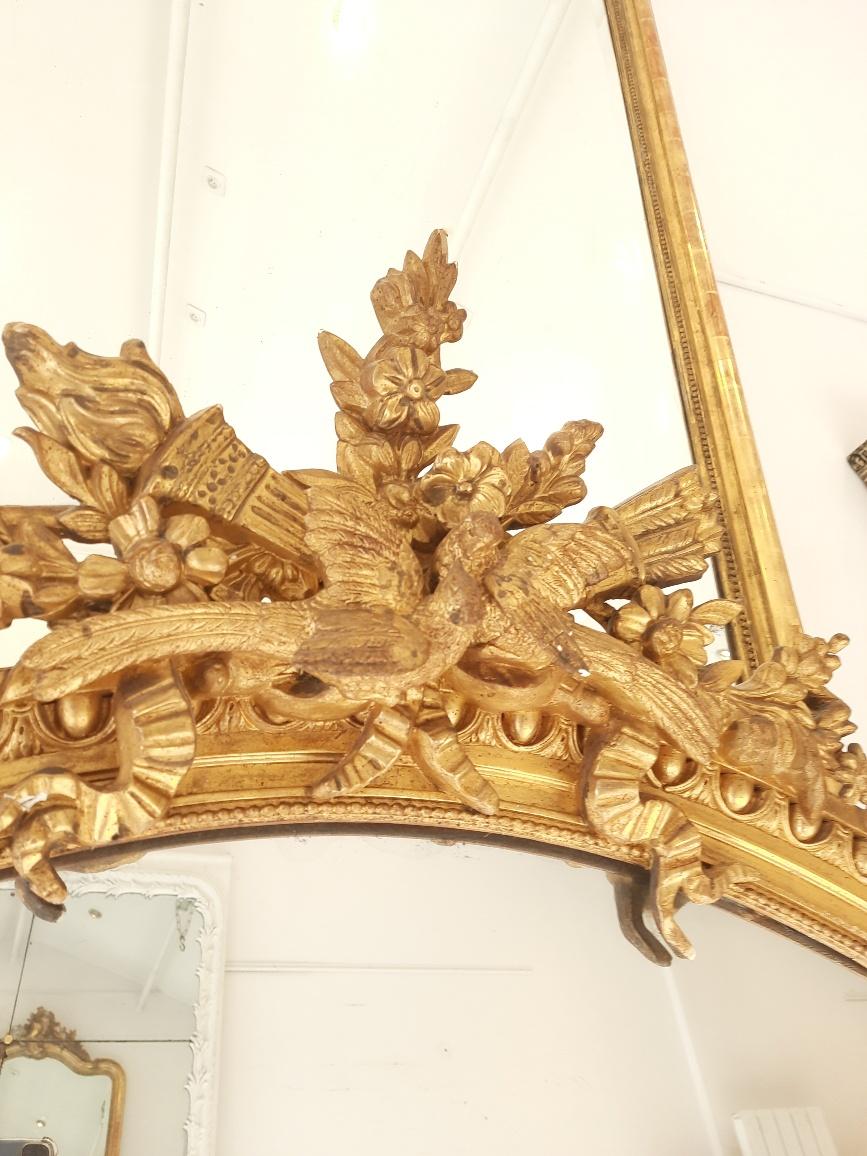 Grand miroir Louis XVI du XIXe siècle, doré et sculpté au gesso.