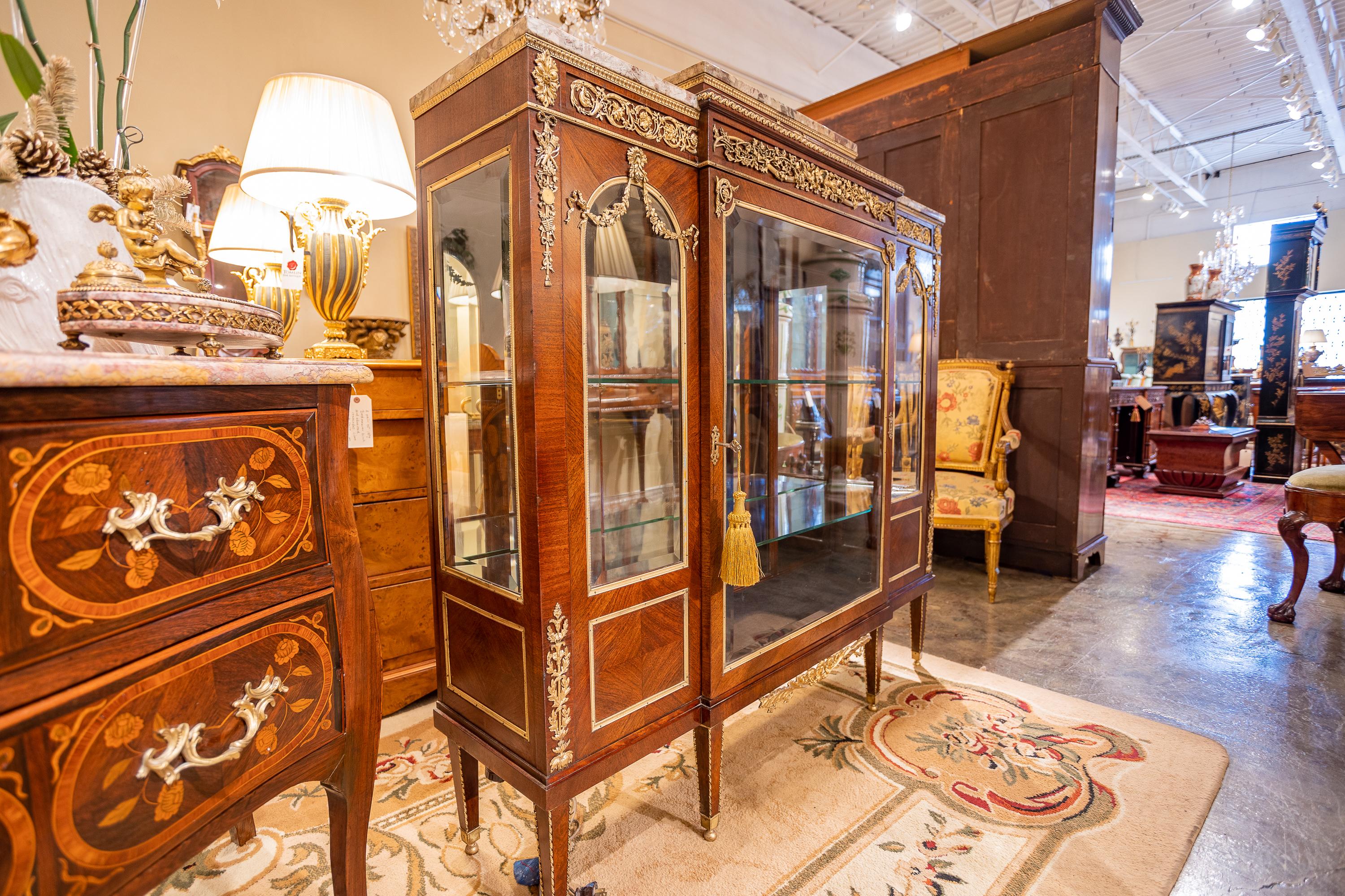 A fine 19th century Mahogany and gilt bronze mounted viewing cabinet signed Maison Forest. Very fine gilt bronze mounts with three sections and marble tops. The cabinet is illuminated and has glass shelves for display. The front door opens as well