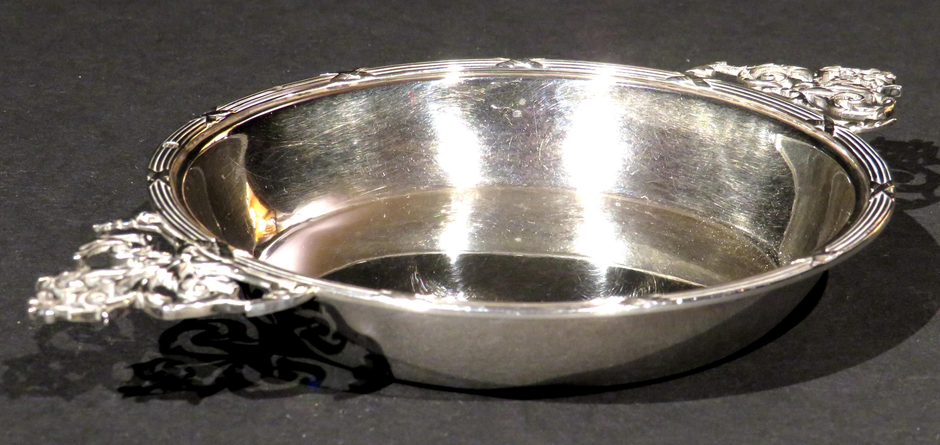 A fine 19th century French silver (.950 fine) porringer or écuelle, showing a circular bowl rising to neoclassical inspired 'reed & ribbon' decorated rim with pierced foliate cast handles, the rim & handles with an impressed Minerva mark denoting