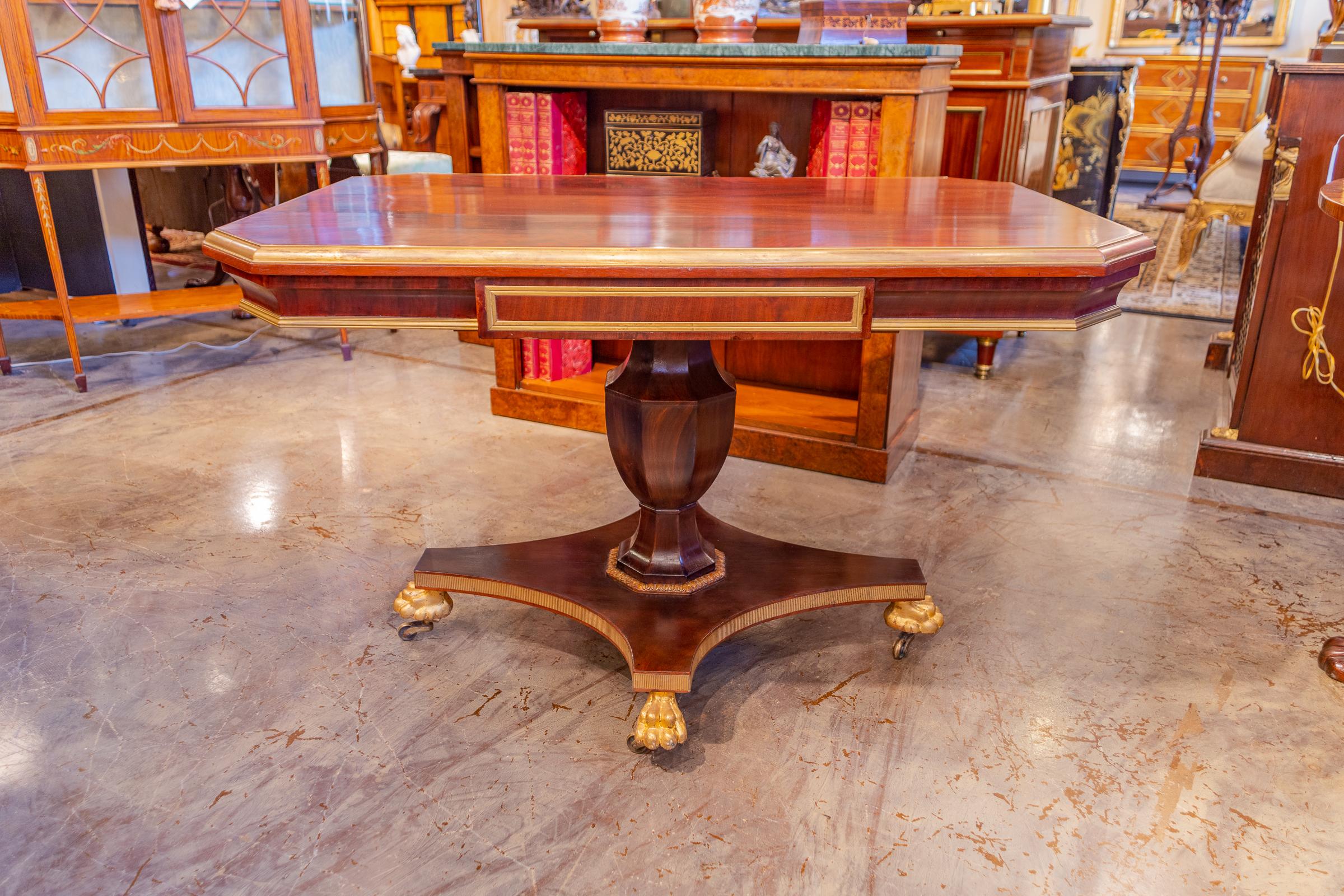 A fine 19th century Russian mahogany and gilt brass inlayed pedestal base library table with gilt pawed feet.