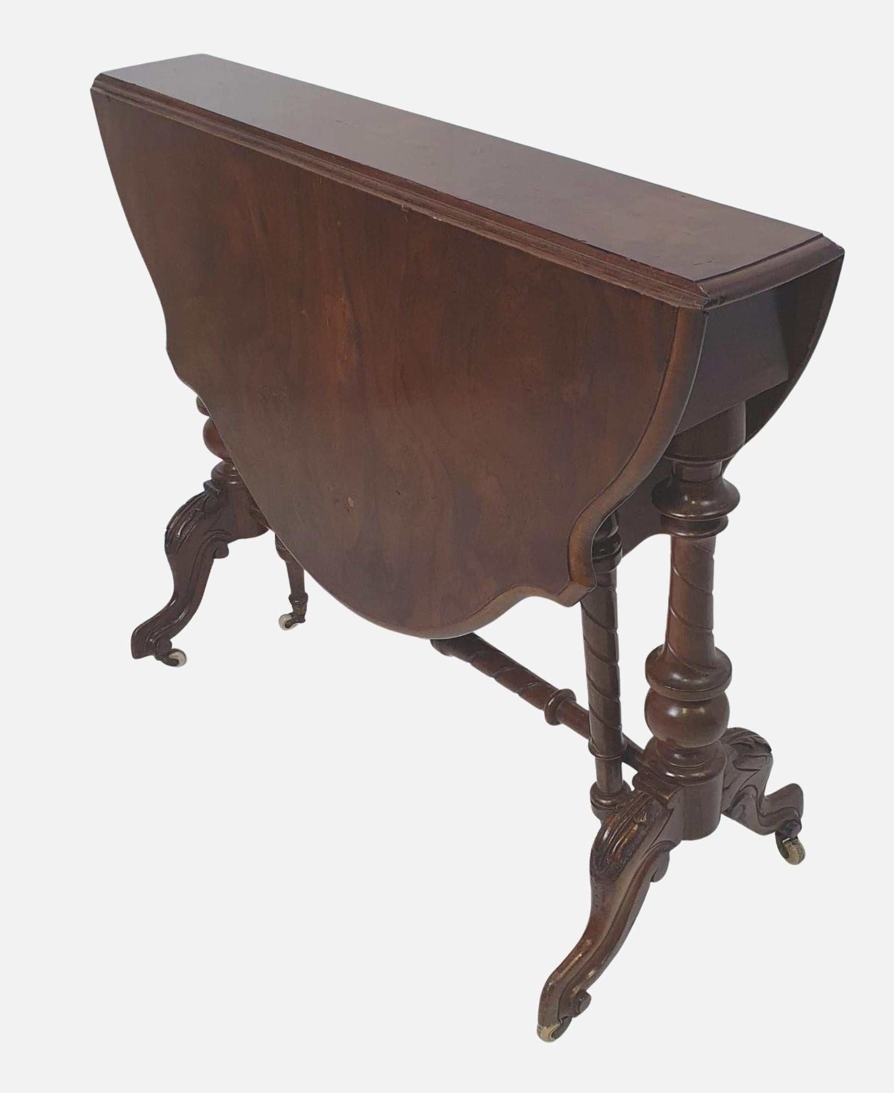 19th Century large size walnut sutherland table, the well figured shaped and moulded top with two drop leaves to either side raised over two turned gate action legs with carved detail and two beautifully turned baluster supports with elegant