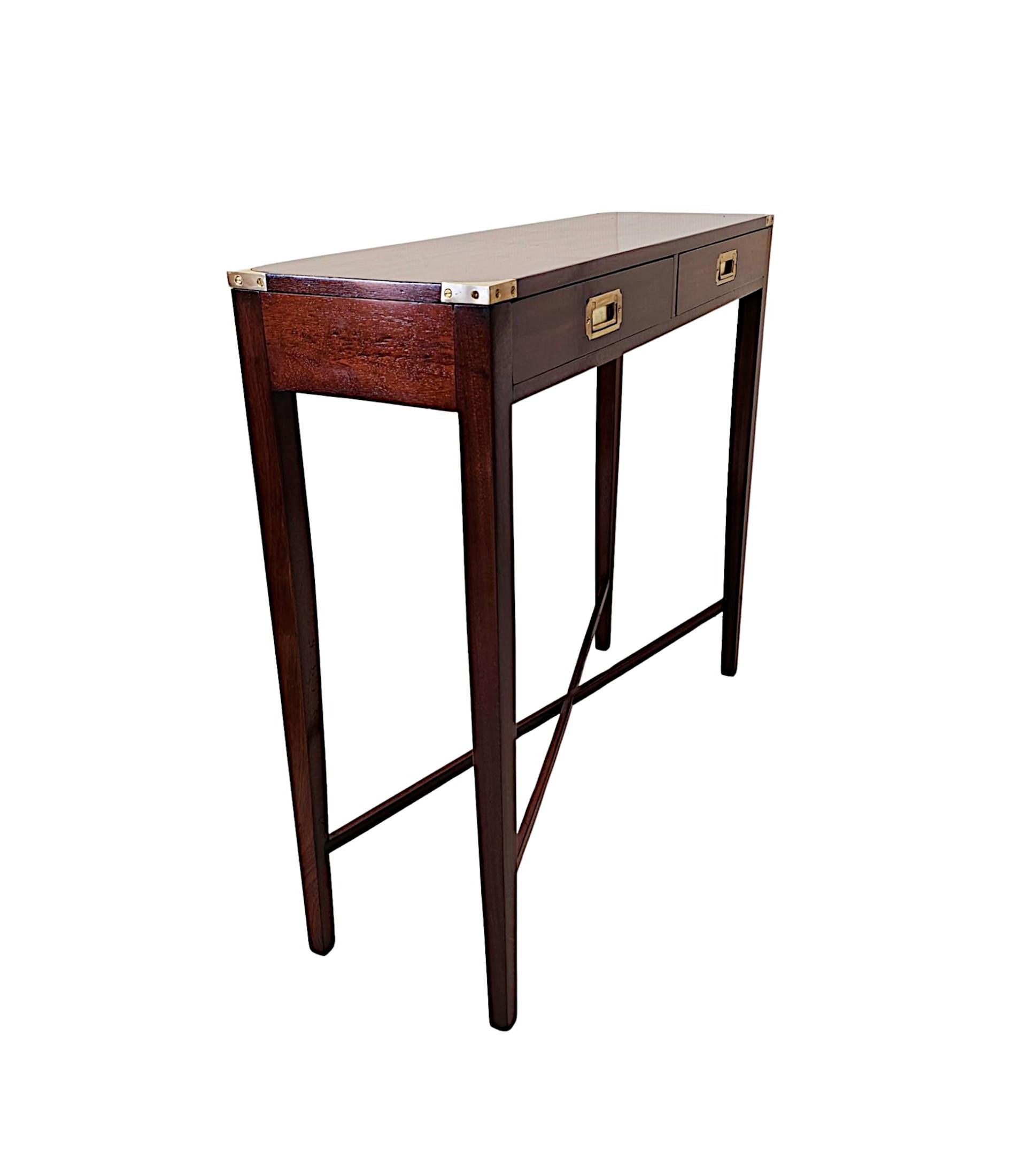 A fine 20th Century mahogany campaign style console table of exceptional quality, finely handmade, brass mounted throughout and with rich patination and grain to the wood.  The well figured, moulded top of rectangular form is fitted with decorative