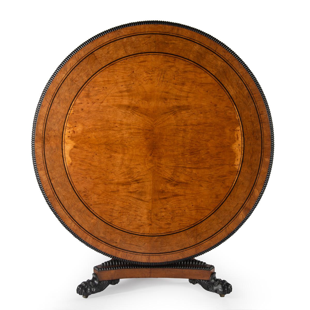 Esta gran mesa central está chapada en roble pollard con molduras de ébano macizo e incrustaciones de ébano en el tablero. Se levanta sobre una columna triangular afilada y una base tripartita de plataforma cóncava, con más enriquecimiento de ébano