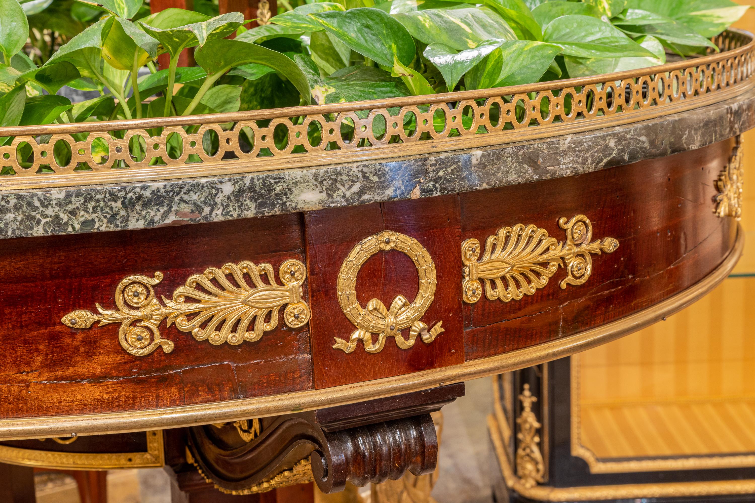 A fine and rare 19th century large Empire mahogany and gilt bronze mounted planter or jardiniere . Marble surround with large Egyptian caryatids holding up the top planter with metal inserts.