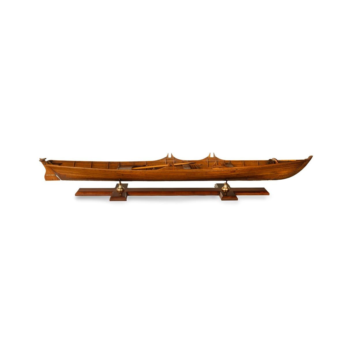 A fine and large model of a Thames wherry. This planked model of a Thames pleasure boat is made of mahogany with copper pins. There is a broad passenger seat behind four thwarts, two of which are adjacent to oar locks set into the saxboard. The two