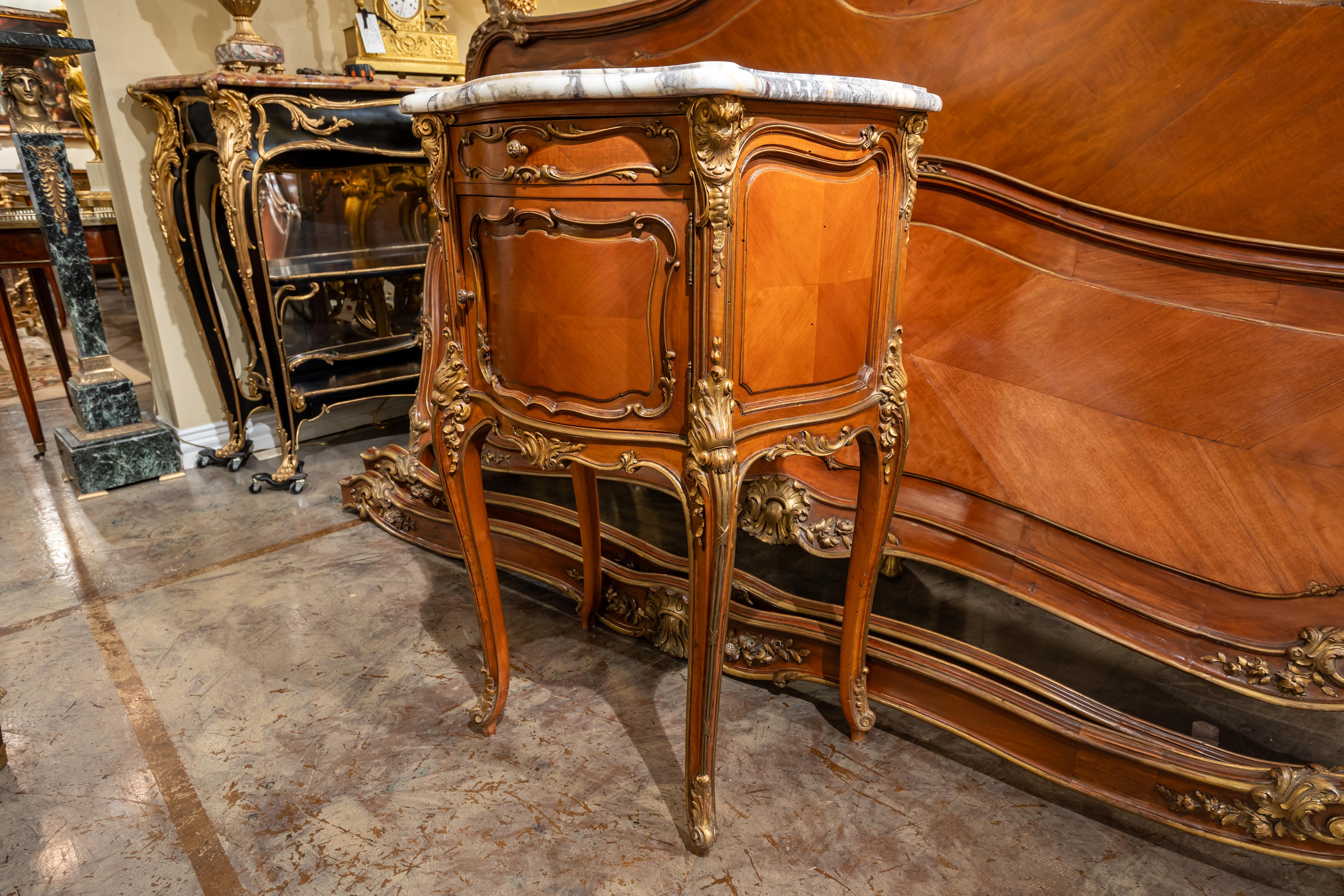 A fine and rare 19th century French Louis XVI walnut and parcel gilt King size headboard and footboard signed Frederic Gustave Quignon. A matching nightstand with a breche Violette marble top. 