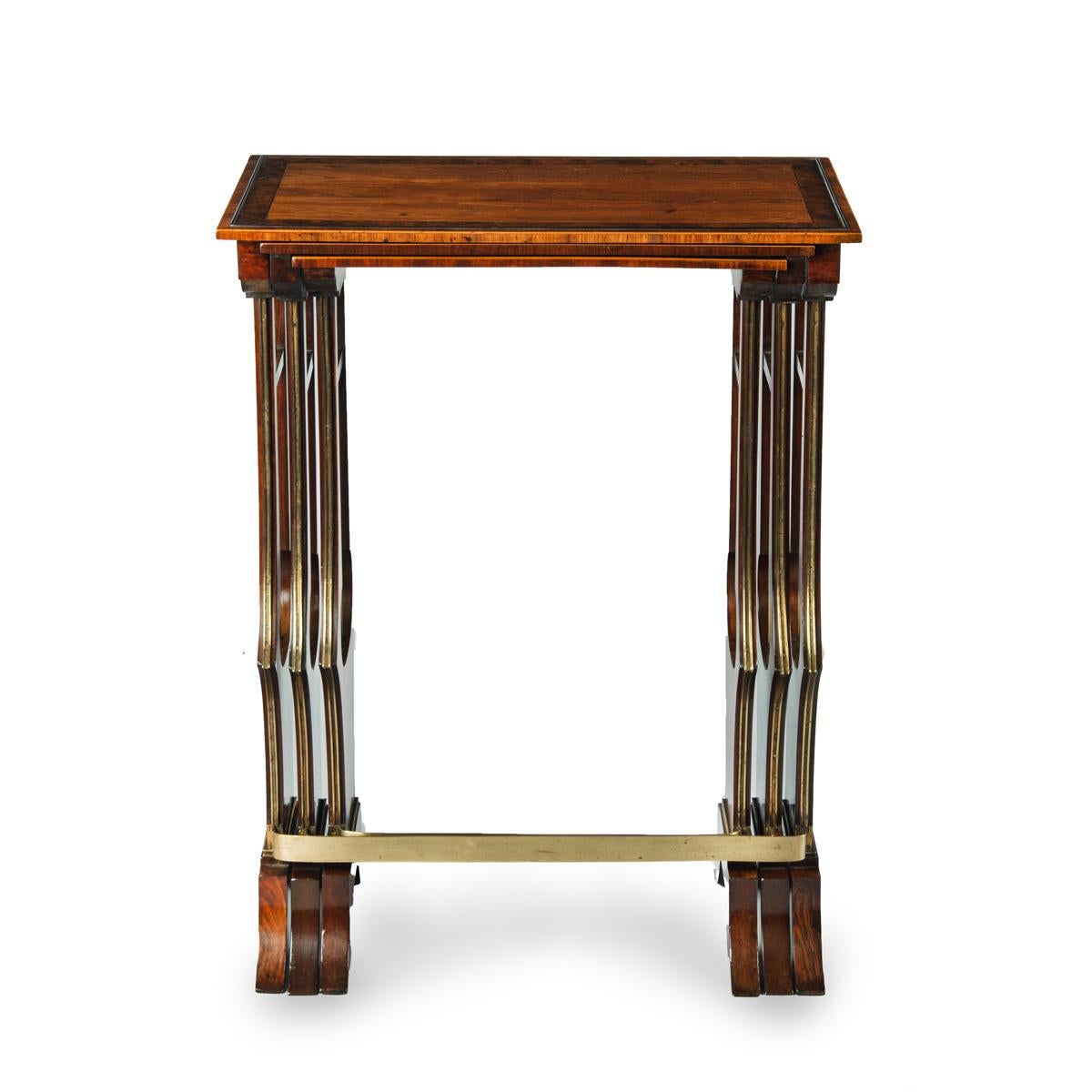 A fine and unusual nest of three Regency tables, each of rectangular form with open lyre end supports, the top one veneered with a tulipwood field and burr oak banding, the second with mahogany and bird’s eye maple and the smallest with Goncalo
