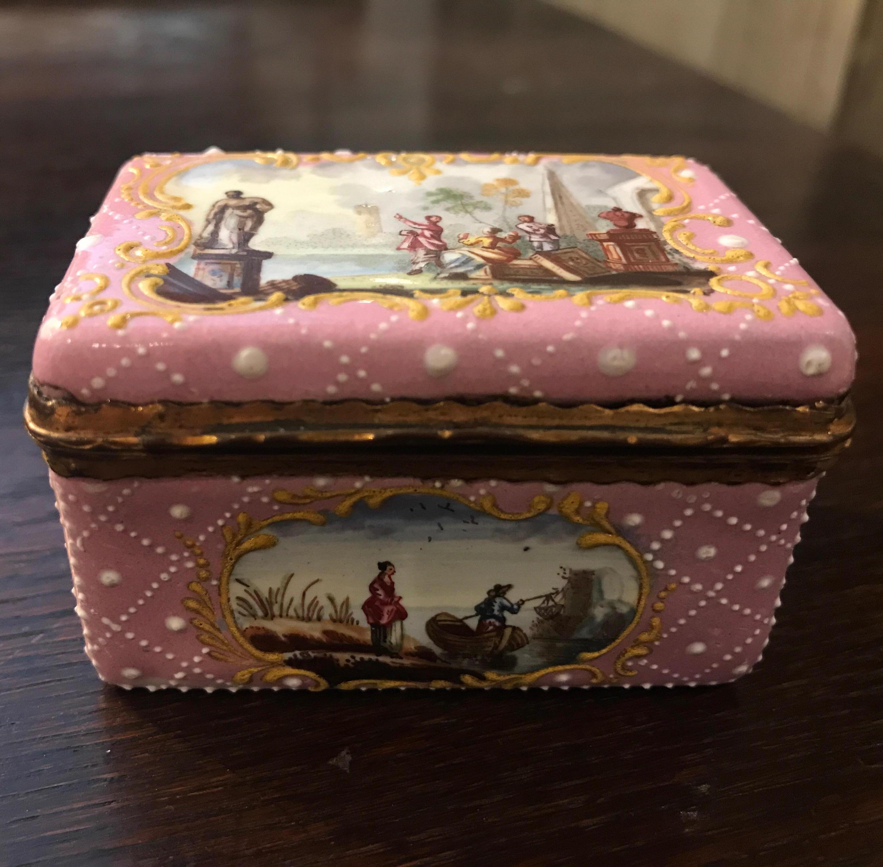 An excellent quality late 18th or early 19th century Battersea enamel snuff or patch box. The pink enamel background with white enamel lattice and a raised gold around the hand painted scenic cartouches on the top and all four sides. The gilt bronze