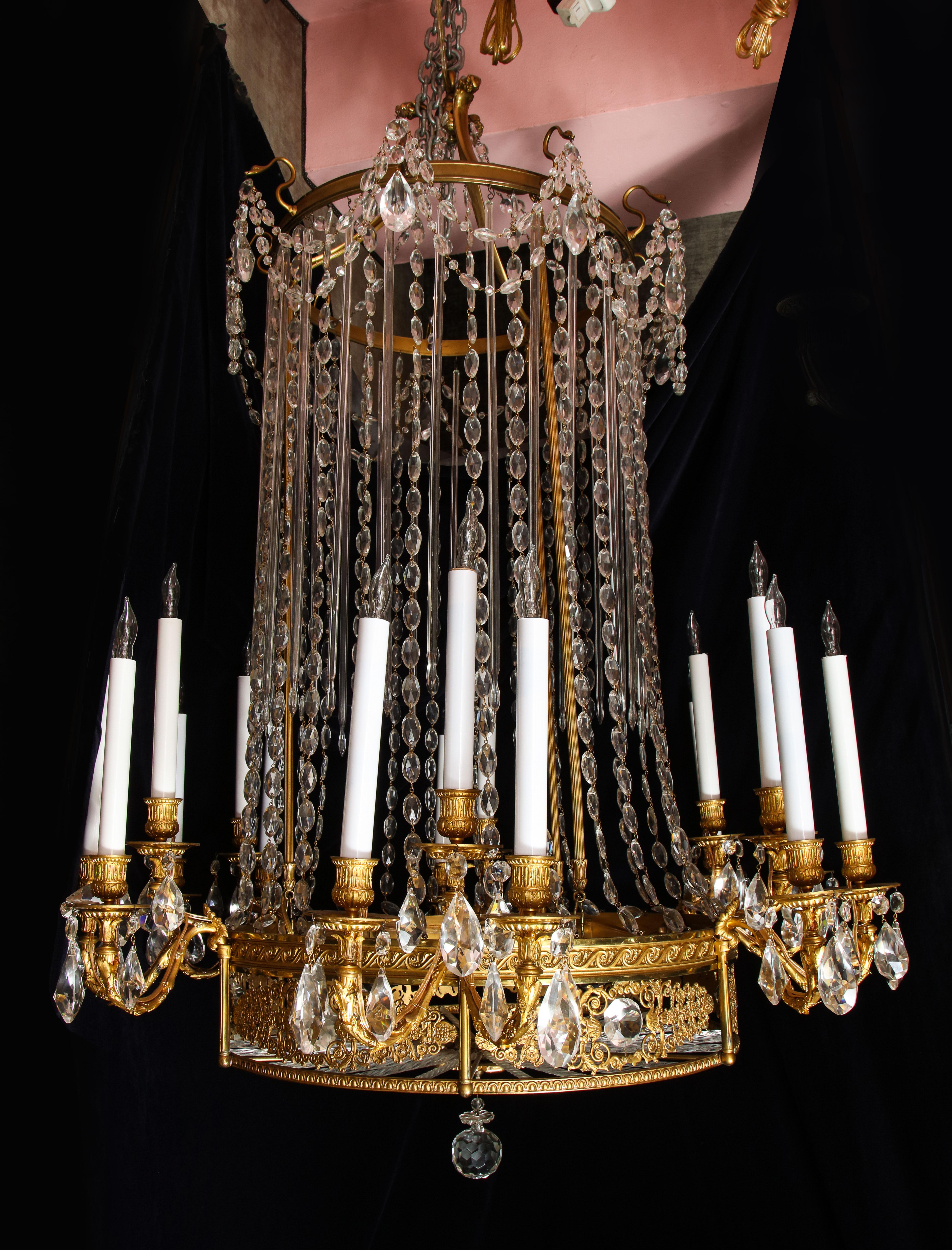 A superb and large antique French Louis XVI Style gilt bronze, cut crystal and glass 18 arm chandelier of exquisite detail embellished with fine cut crystal prisms, chains and glass rods.