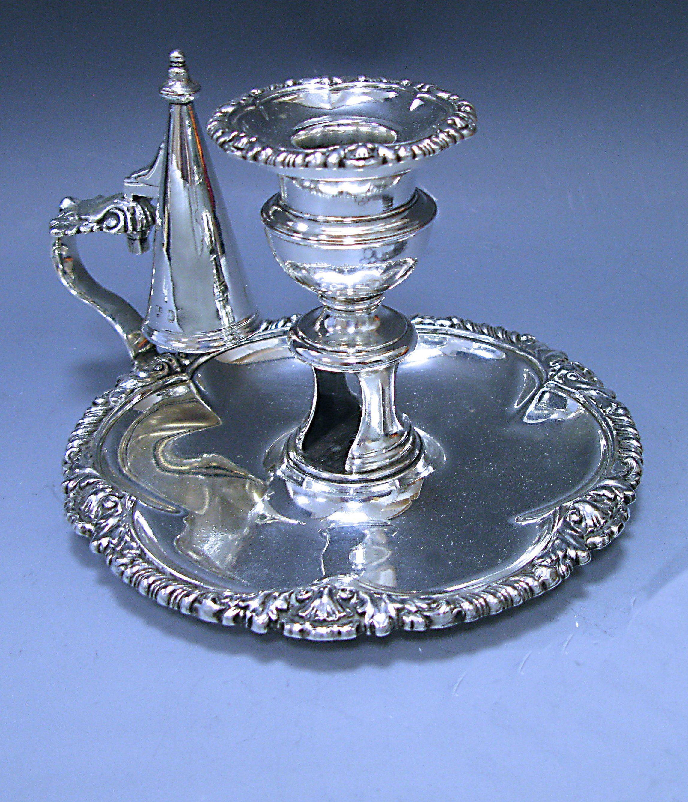 A fine antique George IV sterling silver Chamberstick. The circular base has a gadroon and shell border and the Chamberstick retains the plain silver conical stopper. 

Measures: Height 5.75, 14.61 cm.
 