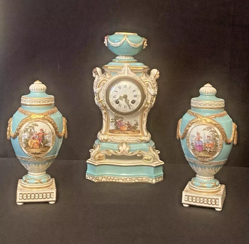 A Fine Antique KPM Berlin Porcelain 3 Piece Clock Set Circa 19th Century

A 19th century Berlin porcelain mantel clock in Turquoise-ground baluster form case, with urn finial & scrolled corners, cherub busts to the sides, finely painted reserves of