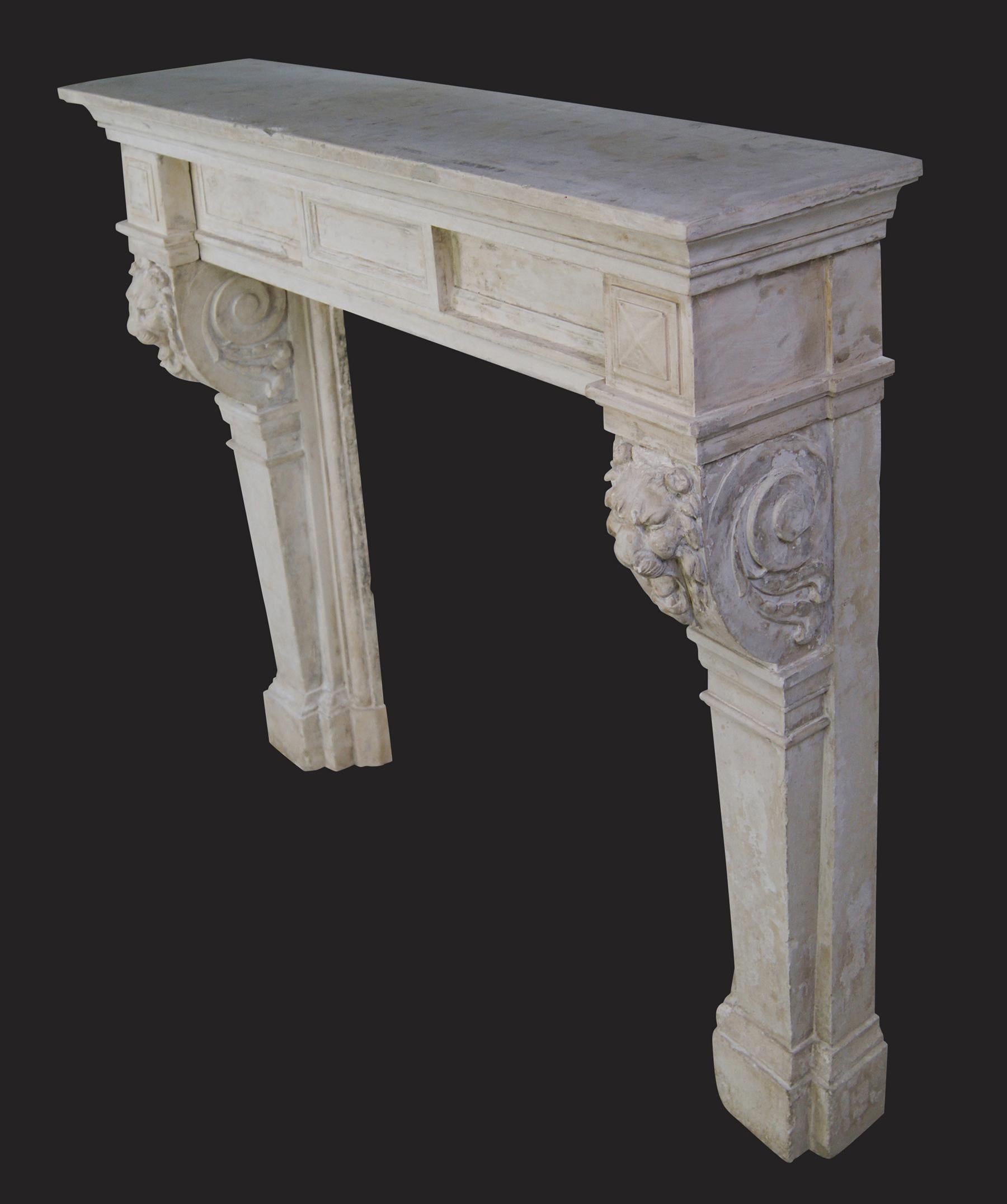 A fine Antique stone chimneypiece of architectural form, with plinthed tapered column-jambs supporting finely carved lion-fronted scrolled corbels.  The diamond corner-blocks flank the simple frieze with central tablet set below a substantial