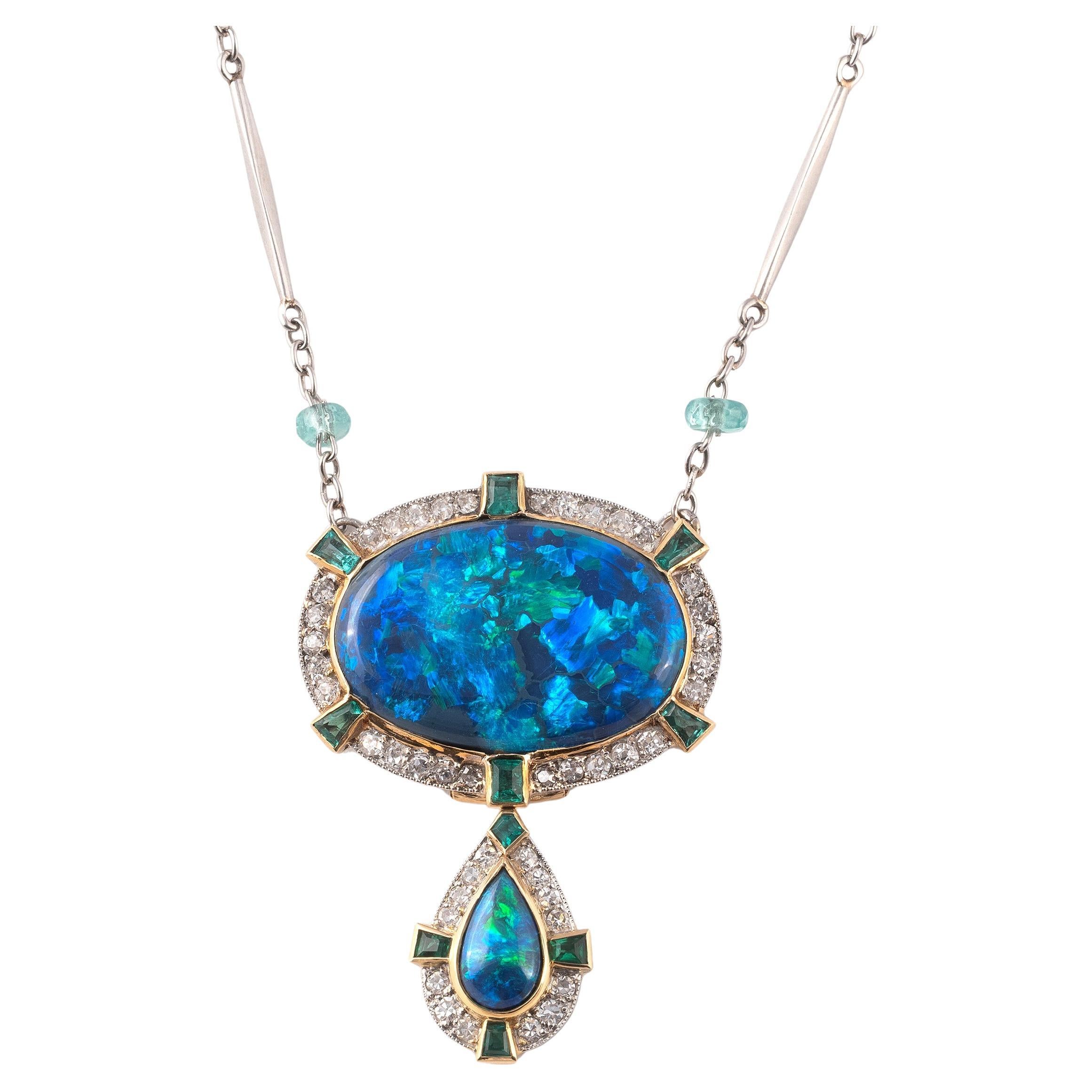Un raffinato pendente Art Déco in opale nero, smeraldi e diamanti.

L'opale nero di forma ovale di circa 10ct (21mm x 14mm x 0,6mm) con un meraviglioso gioco di colori densi: blu, verde e viola; con un contorno di smeraldi taglio baguette e diamanti