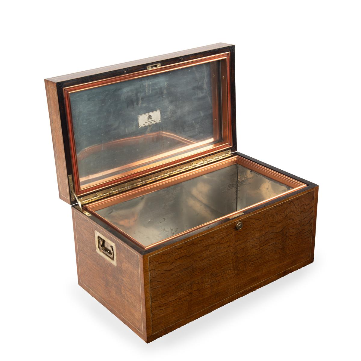 A Fine Art Deco Period Brass-Mounted Ship’s Humidor from the M. Y. Princess, owned by Sir James Gomer Berry, Retailed by Benson and Hedges, this fine humidor is veneered in oak with inlaid brass stringing. The lid has a brass plaque with the M. Y.