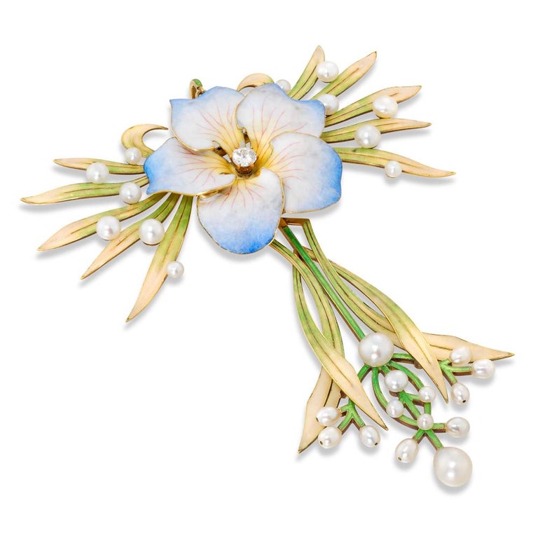 A fine Art Nouveau enamel and pearl flower pendant, the shaded blue, white and yellow enamelled flower head with brilliant-cut diamond centre, to each side a fan of leaves enamelled in shades from green to cream set with pearls at intervals, below