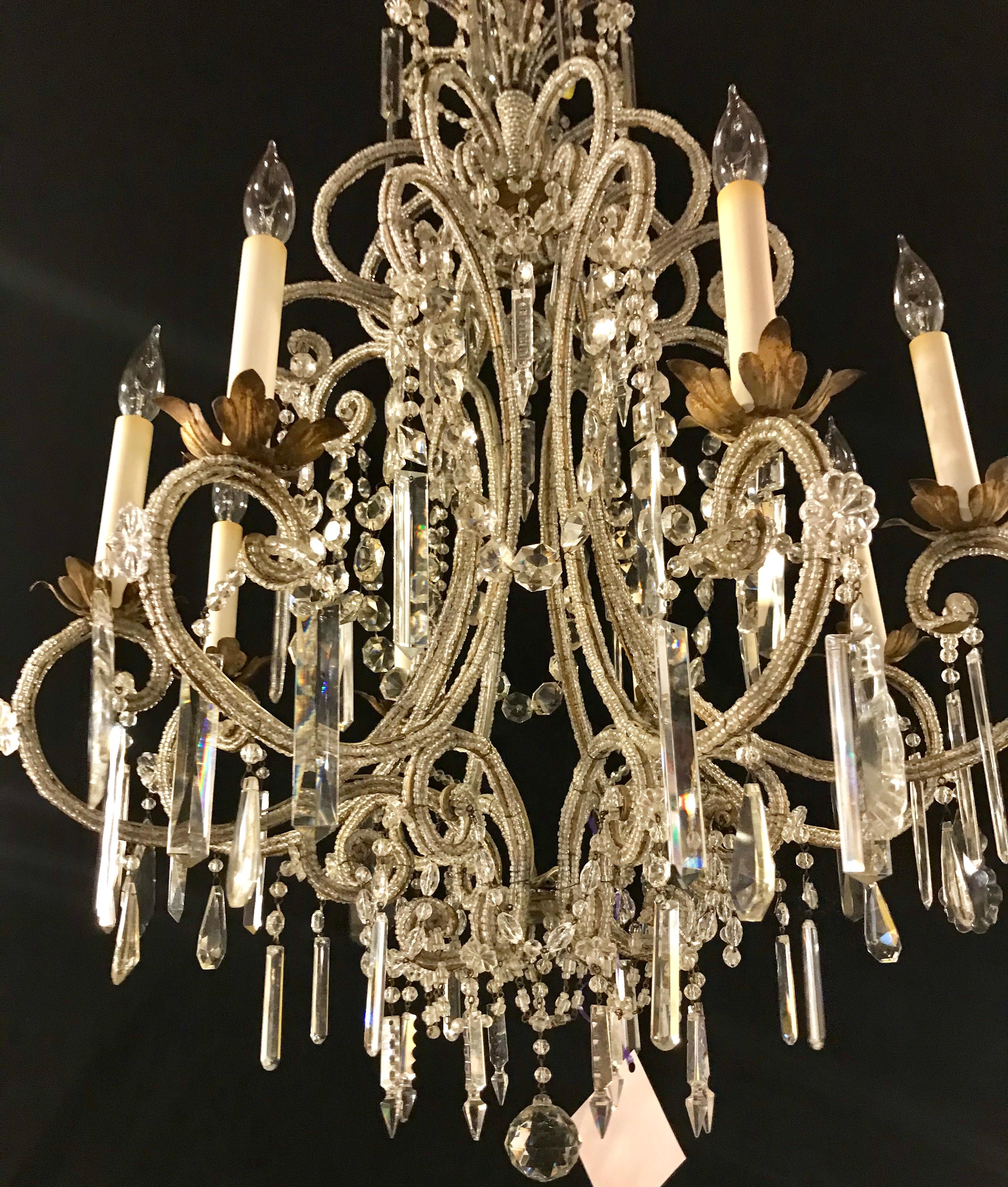 Gilt metal bobeches on this 8-light crystal frame beaded with hanging crystal prisms chandelier. This item has new wiring.