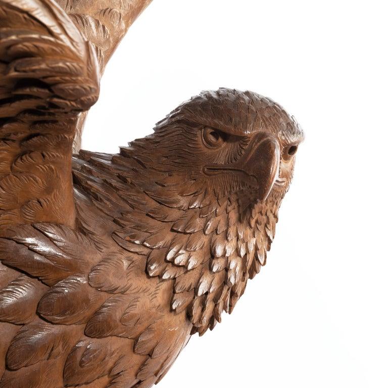 A fine ‘Black Forest’ walnut eagle, shown perched on a rocky outcrop with the wings raised and the head turned to the right, Swiss, circa 1880.
  