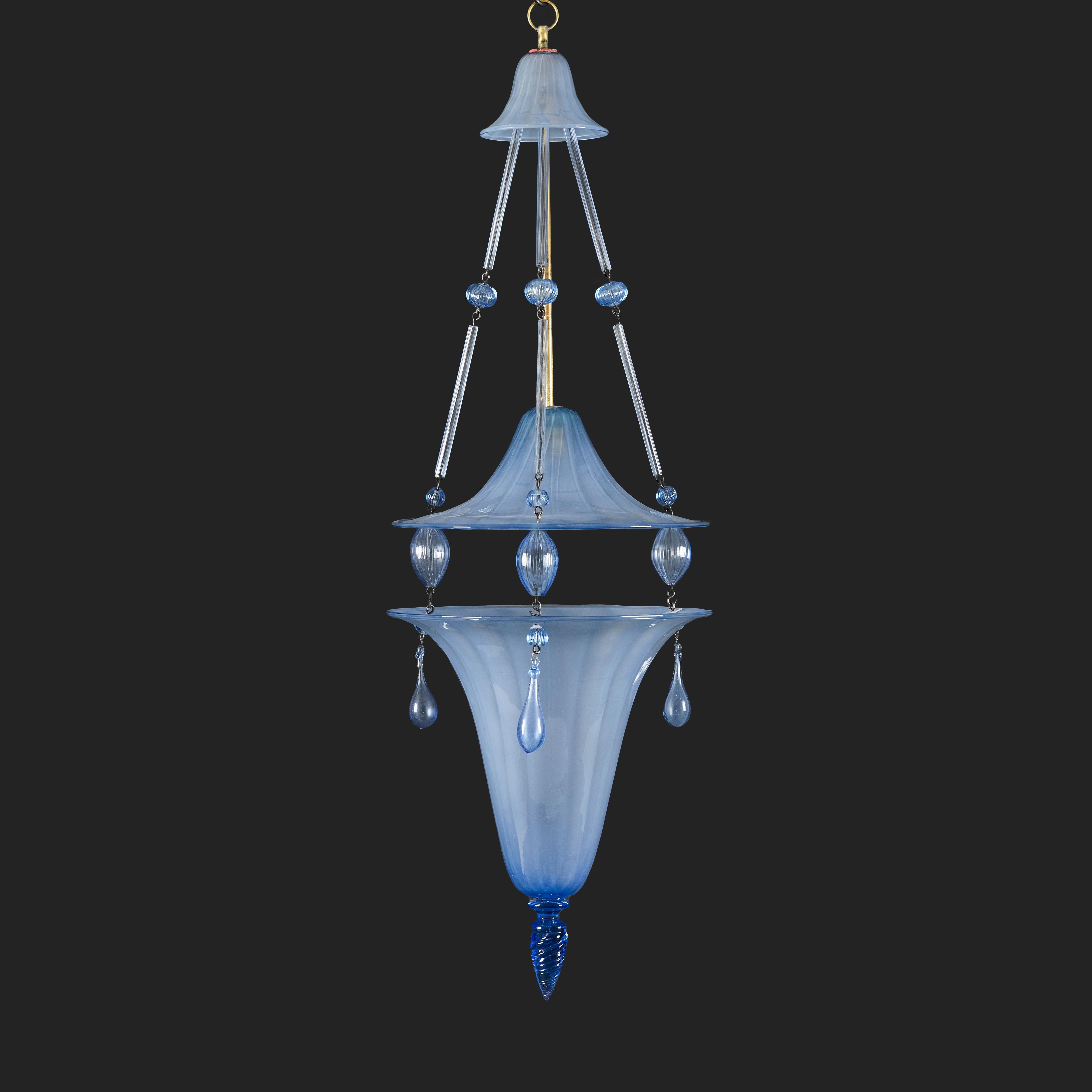 Italy, circa 1940
A fine early twentieth century blue Murano glass hanging lantern, with double canopy connected by glass rods and orbs, with unusual twisted finial to the base, and three droplets to the rim.

Height        96.00cm
Diameter  