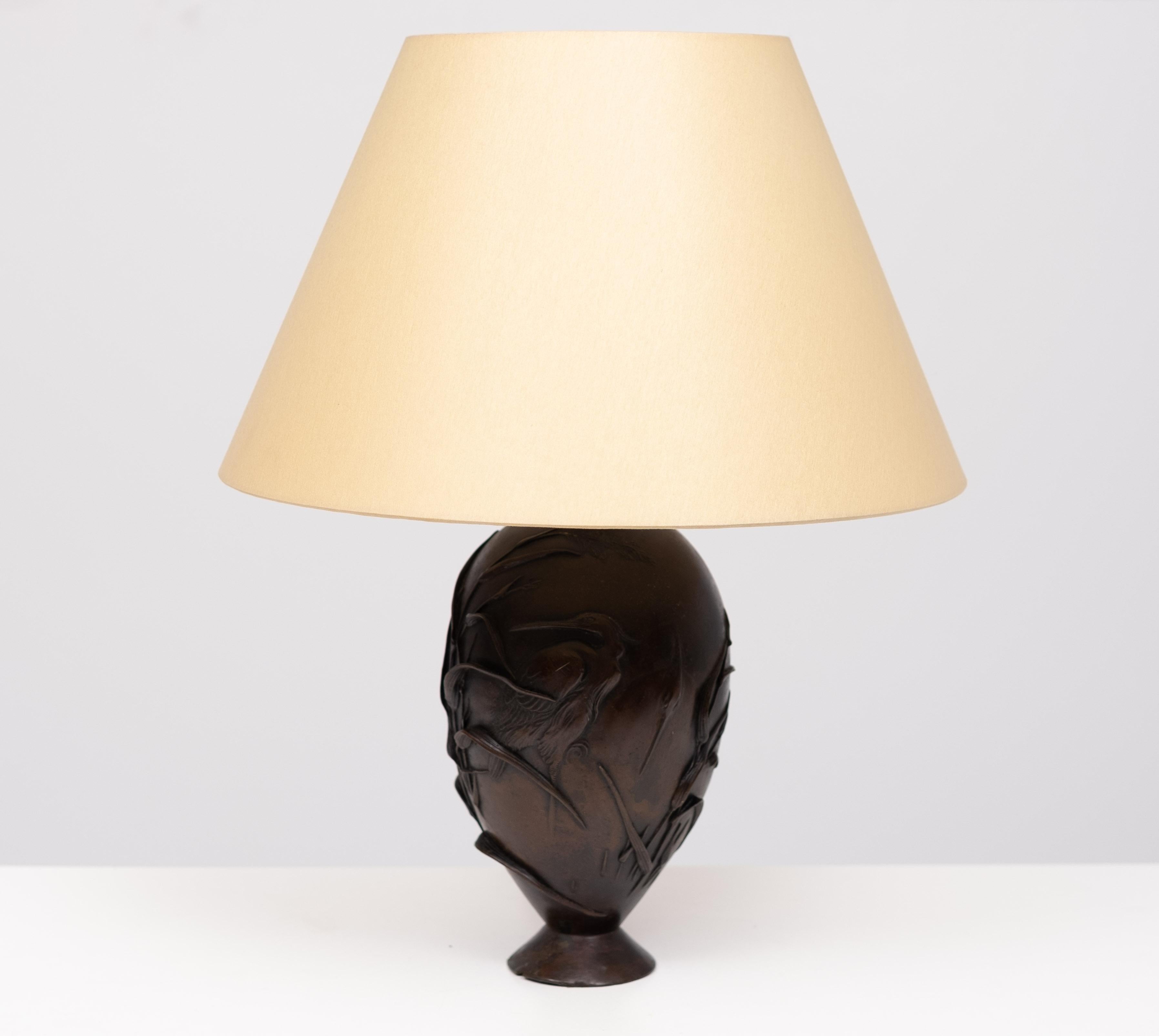  En forma de balaustre, soporte de lámpara, el jarrón de bronce está atractivamente patinado con un acabado marrón rojizo oscuro, finamente trabajado en relieve con detalles incisos que representan a tres  Grullas s en una rama frondosa de bambú, 
