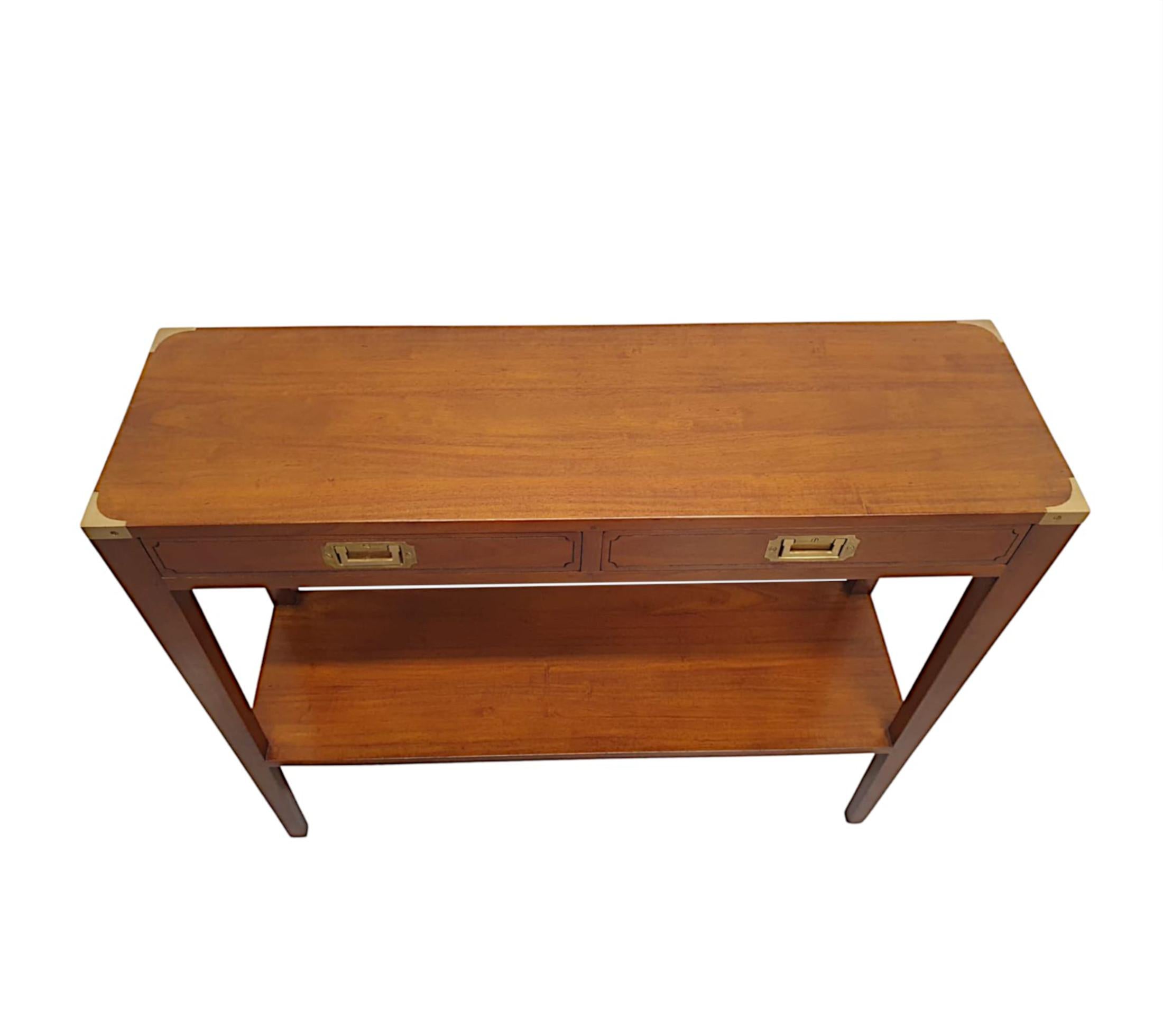 A fine cherrywood, brass mounted campaign style console table of fabulous quality and with a rich patination to the wood.  The moulded top of rectangular form fitted with brass corner mounts is raised over simple two drawer frieze with gorgeous