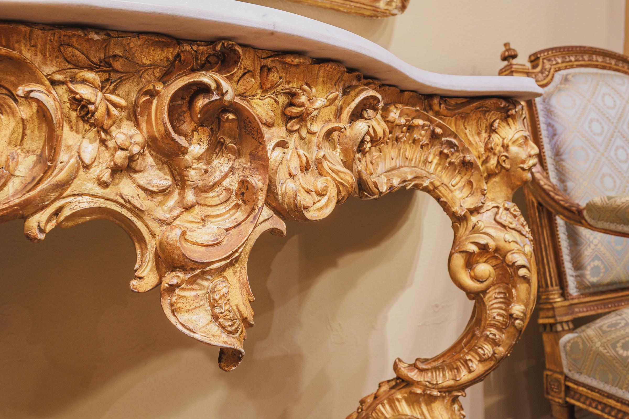 Raffinata consolle Luigi XV del XIX secolo, intagliata e dorata, con piano in marmo di carrara, con grande cura per l'intaglio e i dettagli e teste figurate su entrambi i lati.