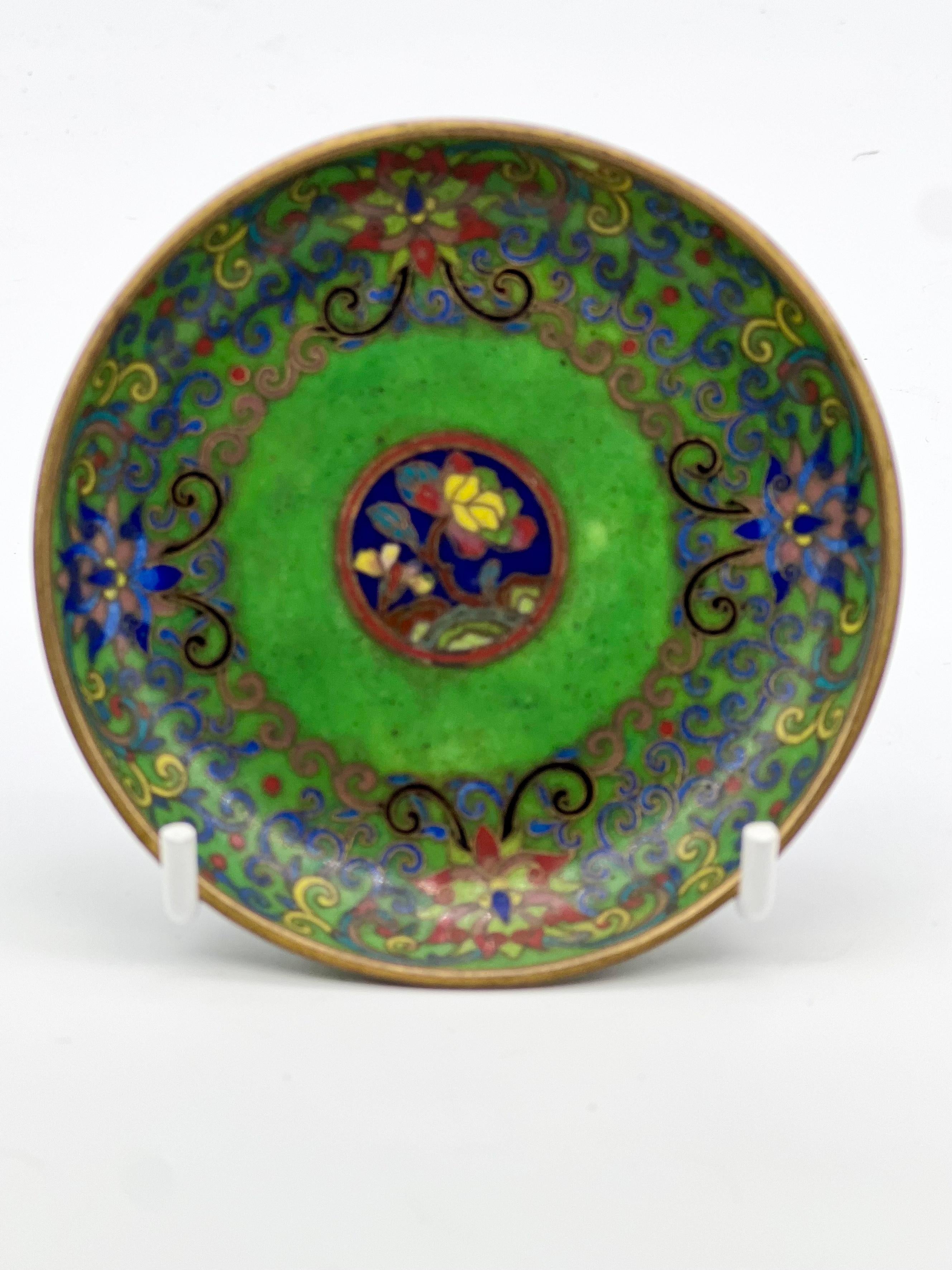A fine Chinese cloisonne enamel plate / dish / tray 19th century.


Worked with gold wire decorated in the centre with a blue ground medallion enclosing two florets encircled with lotus flowers and foliage on a emerald green ground.


In good