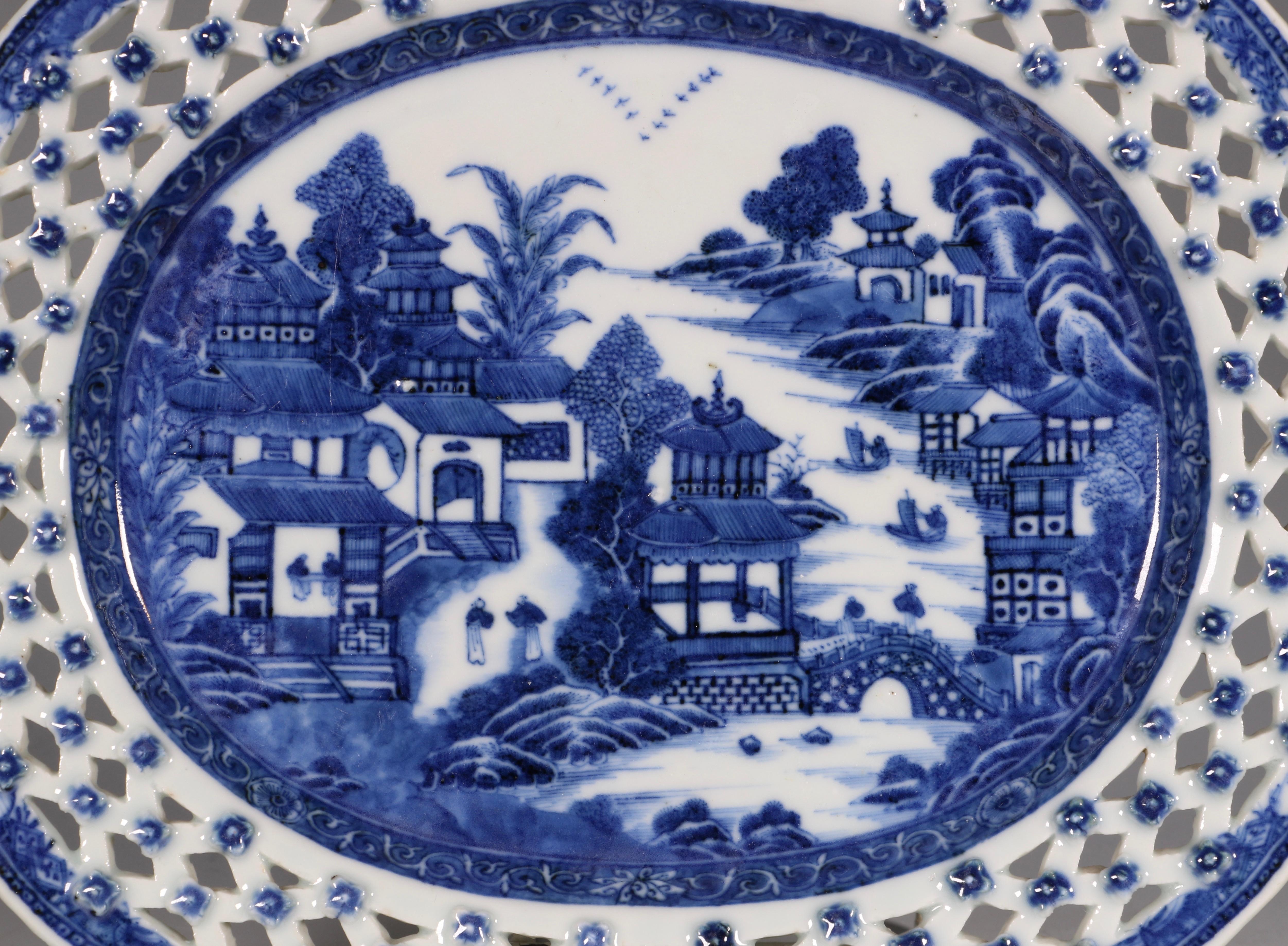 A lobed blue and white basketwork dish. Finely decorated with a Chinese scene of figures and pagodas in a lakeside setting.
The reticulated border with applied florets. This type of ‘basketwork’ with the applied florets originates from wares