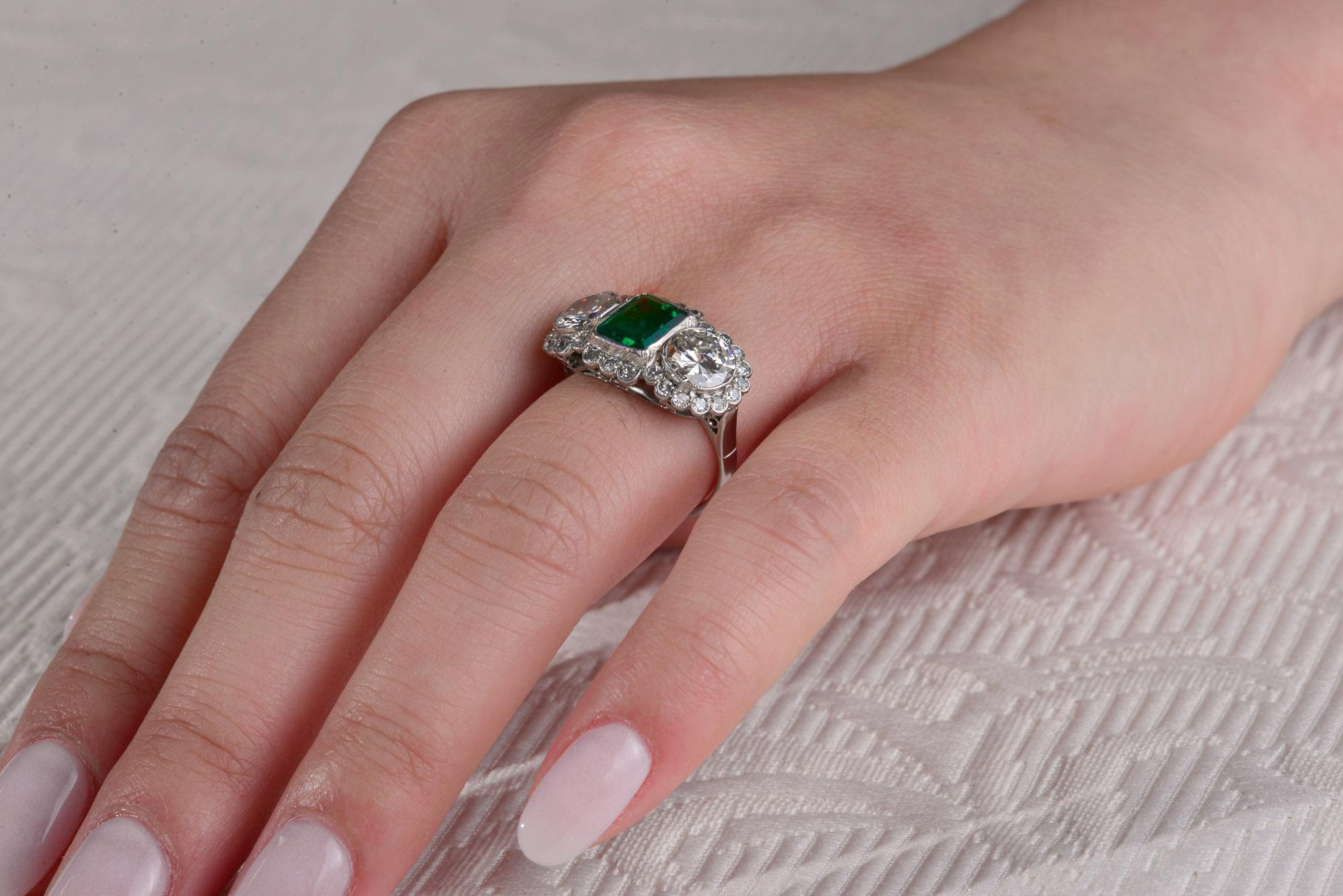 A Fine Columbian Emerald and Diamond Ring  set to the centre with a gorgeous bright 1.40 ct Columbian Emerald  set between two brilliant cut Diamonds of total estimated weight of 2.02 cts and graded in the platinum mount as Colour H , Clarity SI1