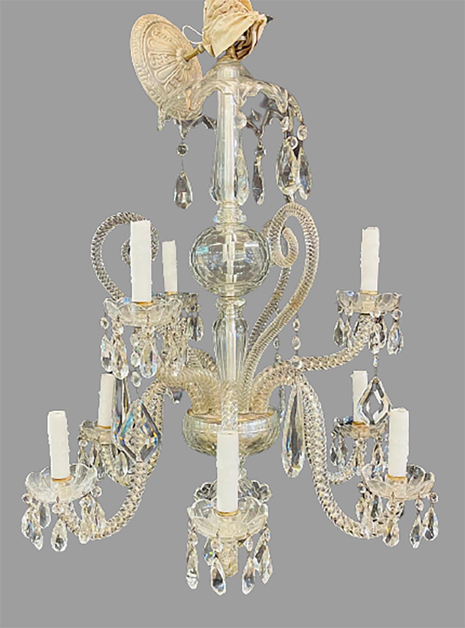 A fine cut crystal Venetian style chandelier having nine lighted arms on a central crystal column center support. The large and impressive finely cut crystals the likes of Schonbek hanging on twisted glass arms. 
This fine chandelier was removed