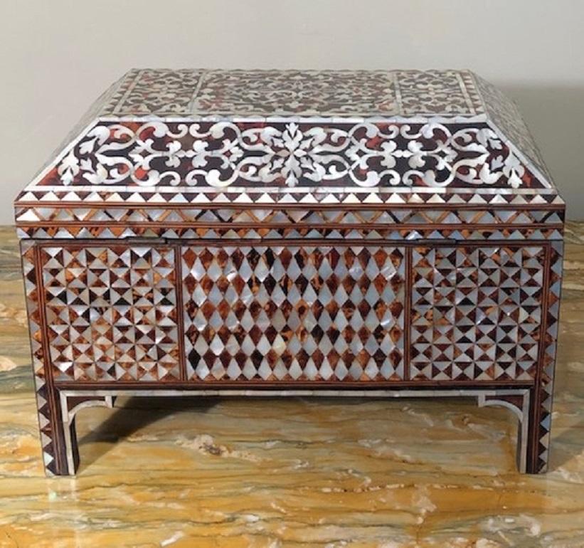 A fine mother of pearl and tortoiseshell ground inlaid chest of rectangular form raised on short legs with a hinged coffered lid. The sides, front and back are covered in inlaid panels of triangular geometric and rectangular shapes with beautiful