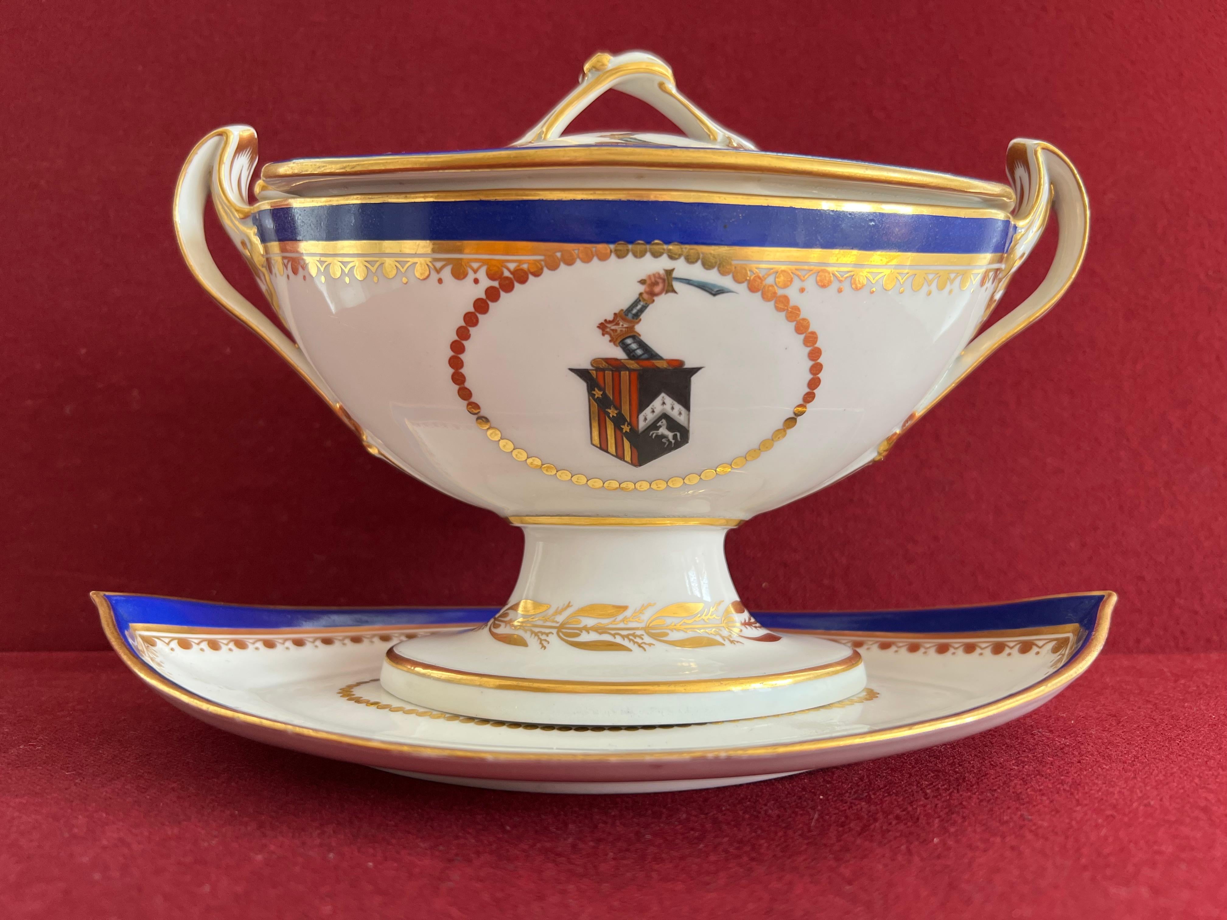 A fine Derby porcelain sauce tureen and stand c.1795-1800. Of navette shape, finely decorated with a blue band with gilding and the crest of the Elton family to the centre of each piece. In Heraldry, the crest is described as follows: Paly of six or