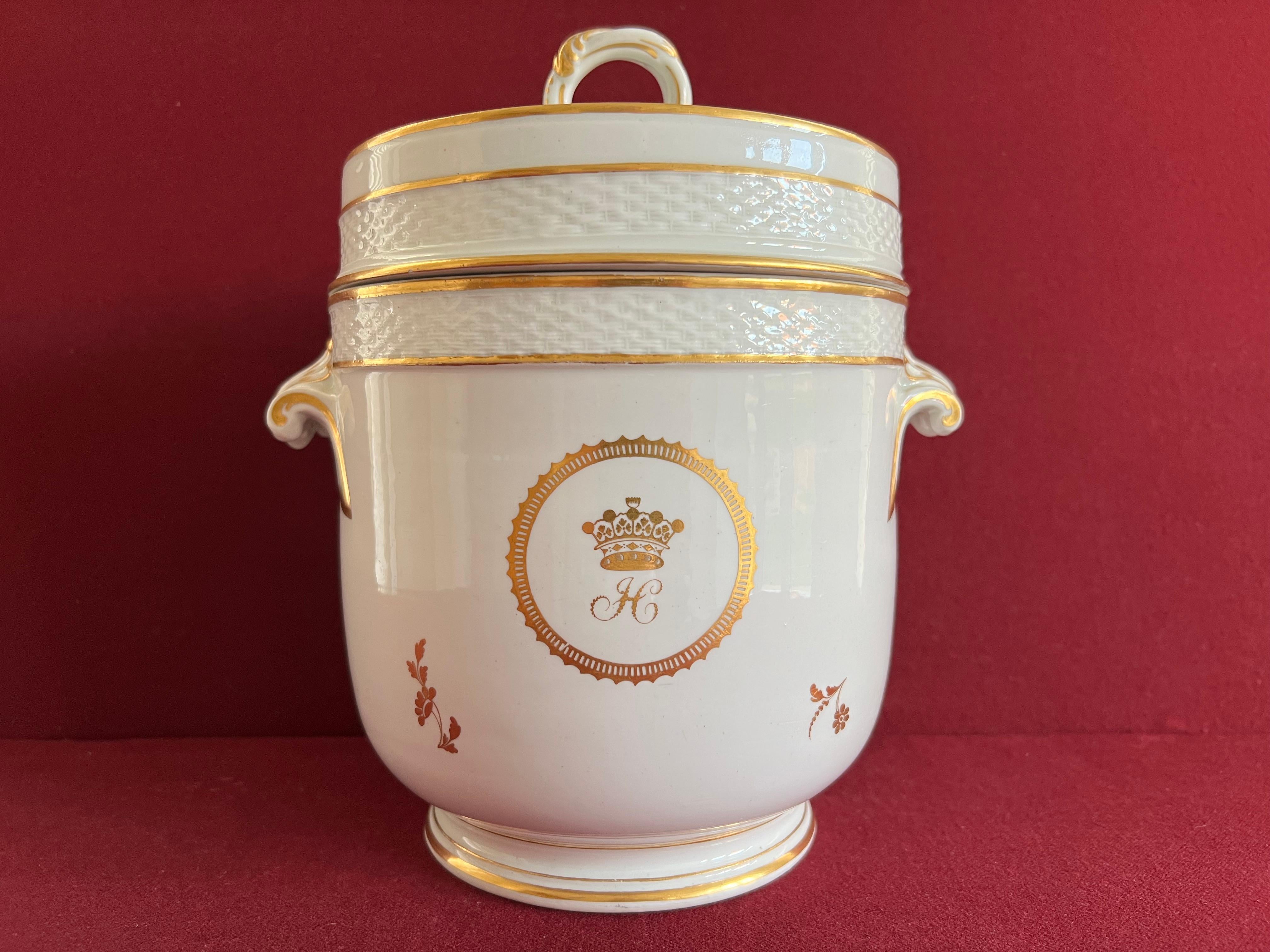 A wonderful 18th century Derby Porcelain Ice Pail & Cover c.1790. White porcelain decorated with a coronet of a Marquess and the letter ‘H’ on either side and scattered flowers in gold. Puce factory mark for the Duesbury period.

Condition: