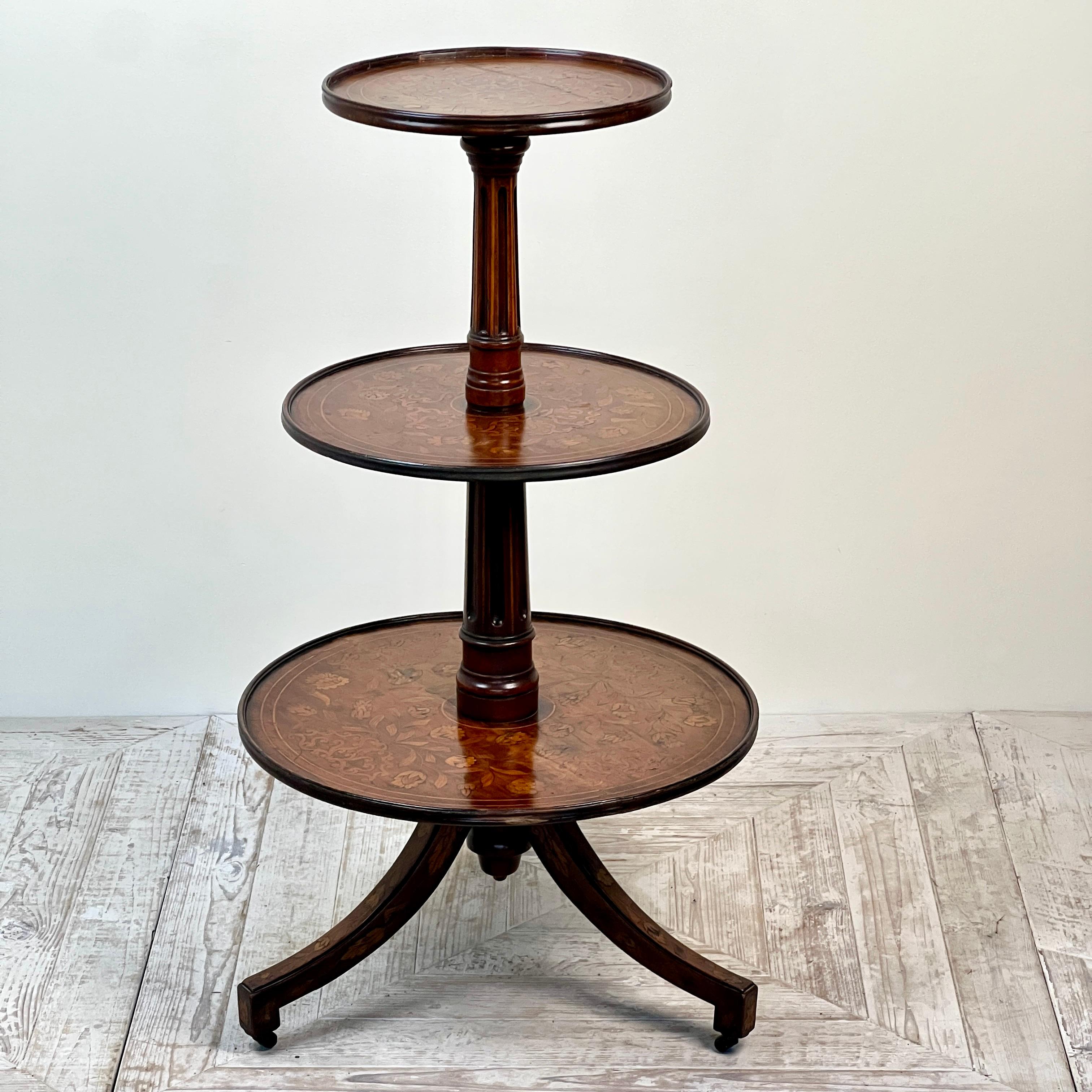 Preciosa cómoda holandesa antigua de caoba y marquetería de tres pisos, de finales del siglo XVIII o principios del XIX.

Consta de tres bandejas circulares graduadas, cada una con incrustaciones de un intrincado diseño de volutas en el centro y
