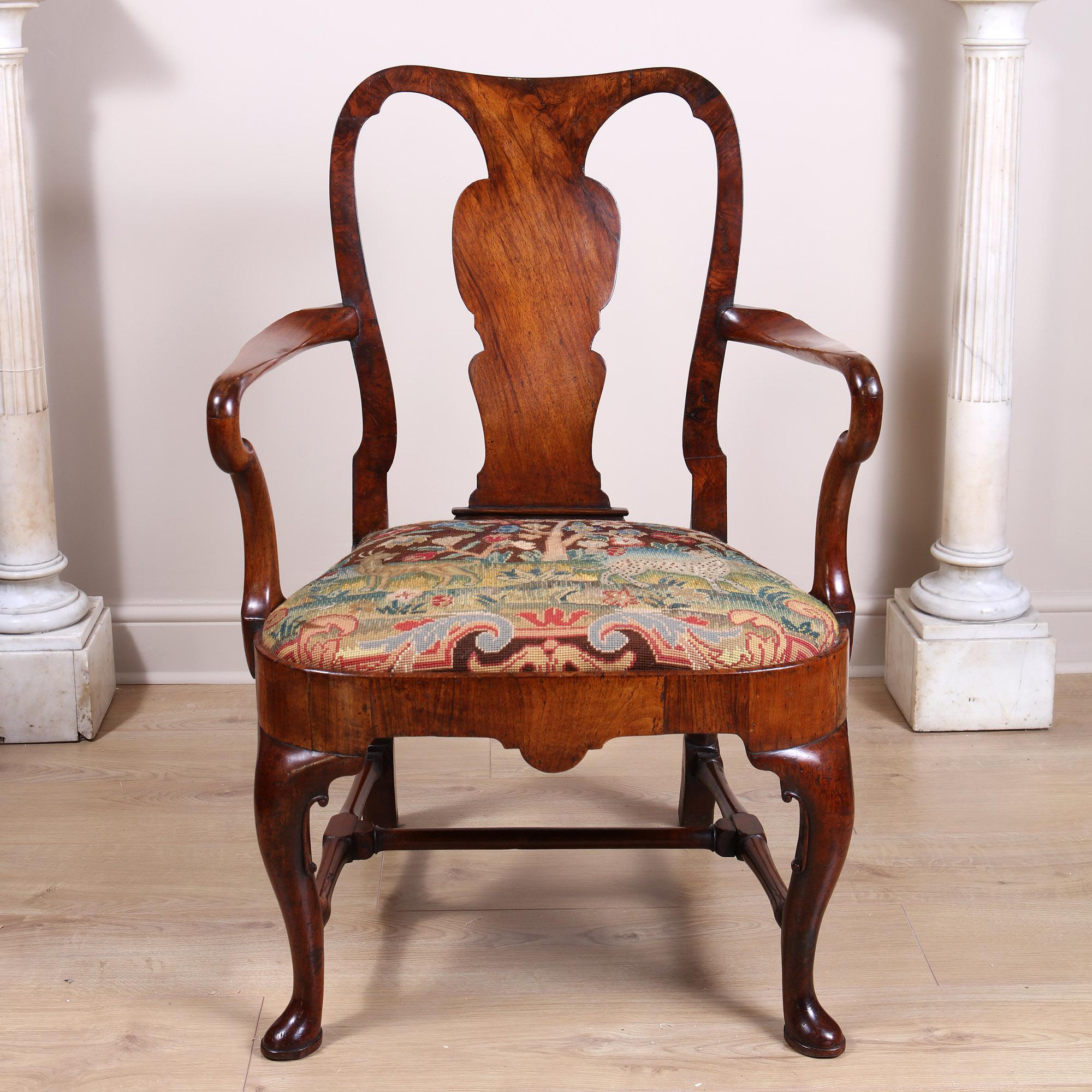 A fine early 18th-century walnut Shepherd’s Crook armchair with a vase-shaped splat and shepherd’s crook arm supports, on scroll eared cabriole front legs, with splayed block and columnar rear legs with a turned H stretcher. The seat is upholstered