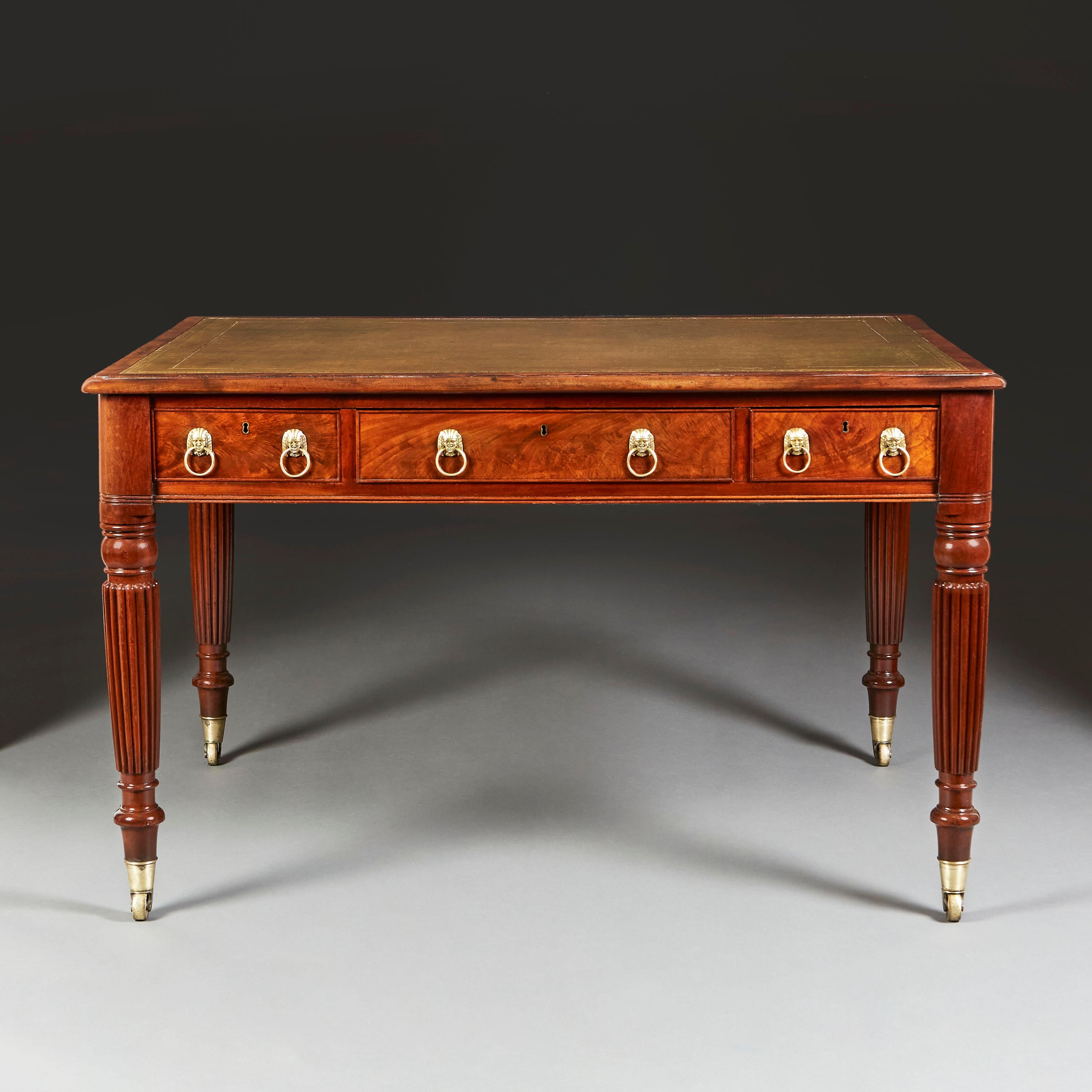 Une belle table à écrire en acajou du début du 19ème siècle avec 6 tiroirs, 3 à l'arrière et 3 à l'avant, avec des poignées en forme de masque égyptien, dessus en cuir vert, le tout soutenu par des pieds fuselés et cannelés, terminés par des