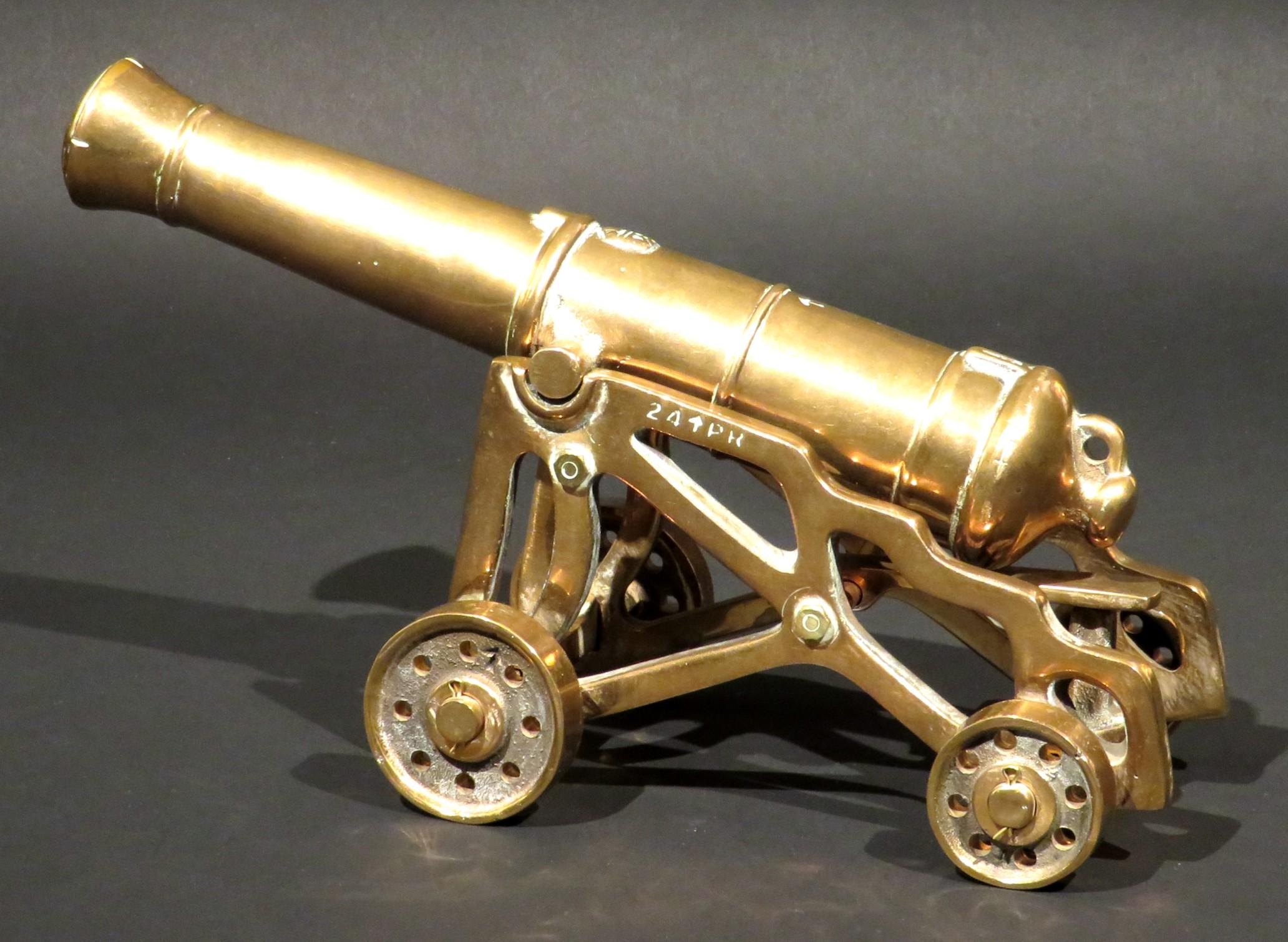 A finely cast model of an early 19th century British 24-pounder smoothbore muzzle-loading artillery cannon, together with its garrison style carriage. 
Both cast in heavy gauge 'bell metal', the gun is accurately represented with the Royal Cypher of